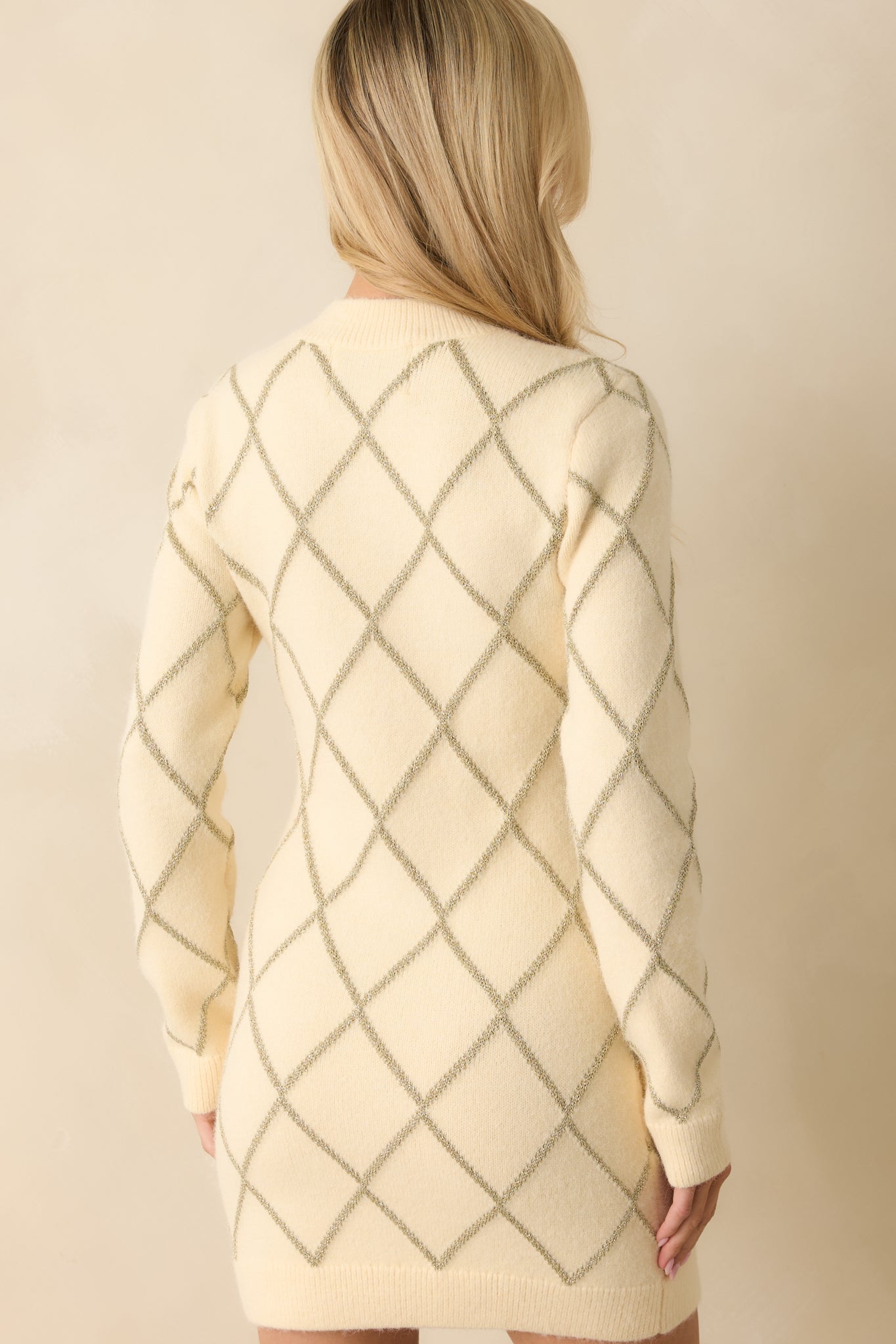 Rear view of the sweater dress showing its relaxed silhouette and subtle shimmering argyle design.