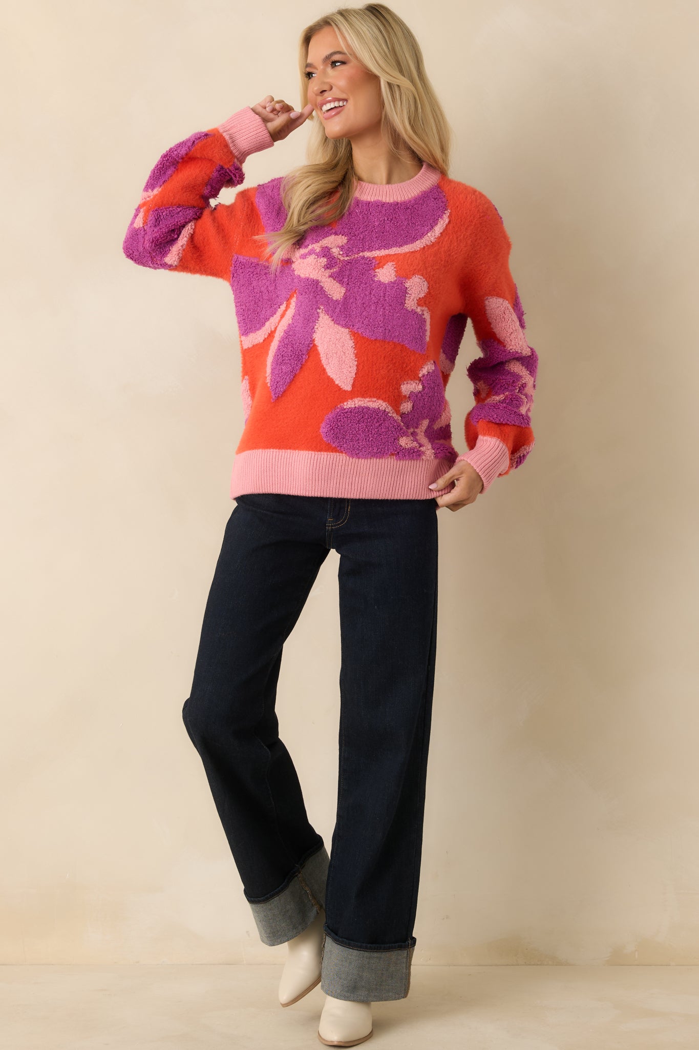 The sweater displays ribbed trim at the cuffs, hem, and neckline, accentuating the colorful floral design.