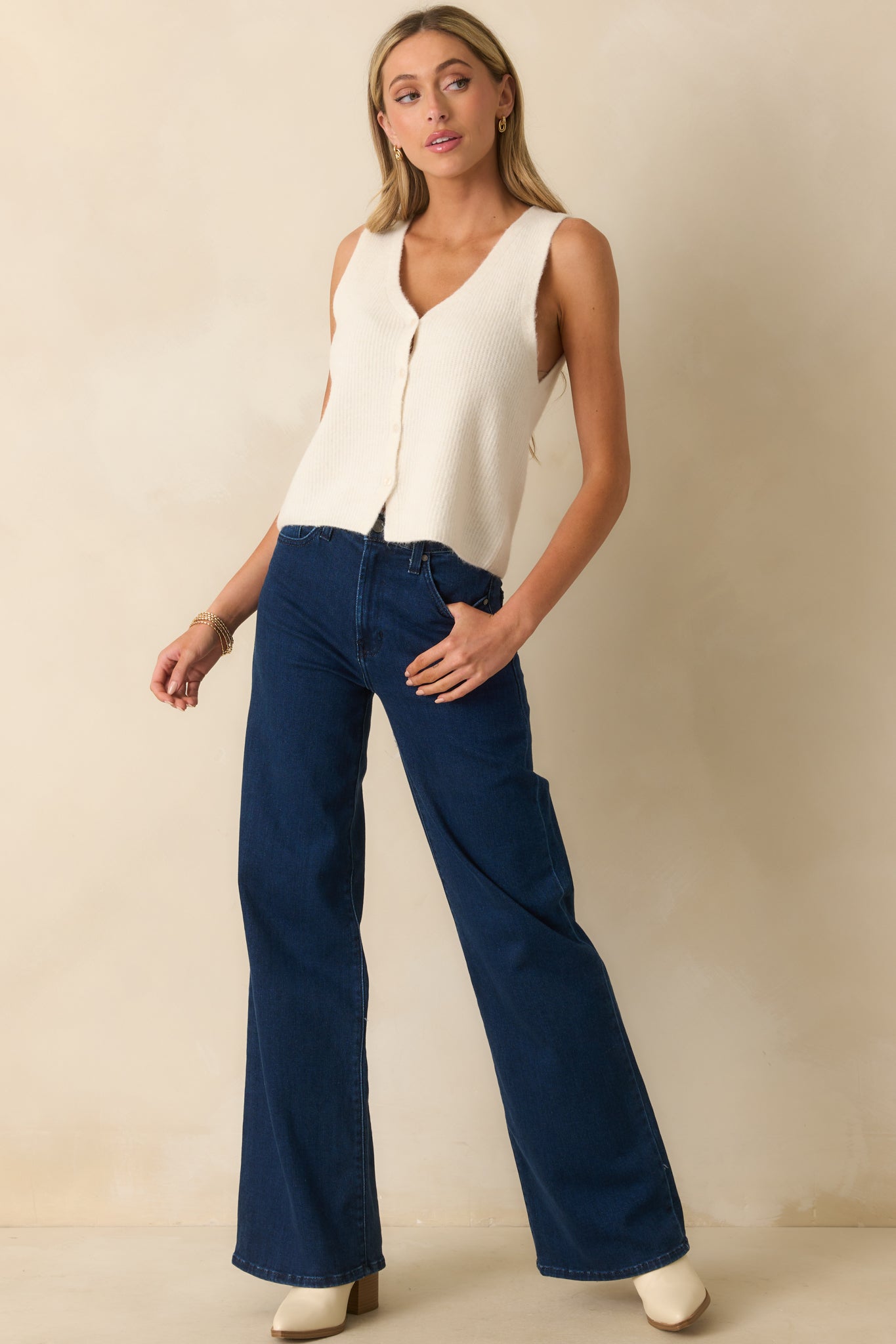 Vest featuring a functional button front and ribbed knit fabric, angled view.