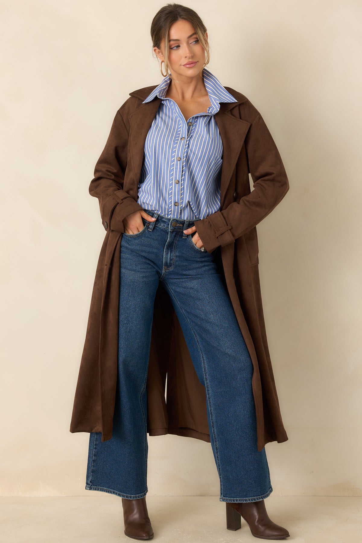 Longline coat features a structured notched collar, defined waist, and clean button detailing with a streamlined silhouette.