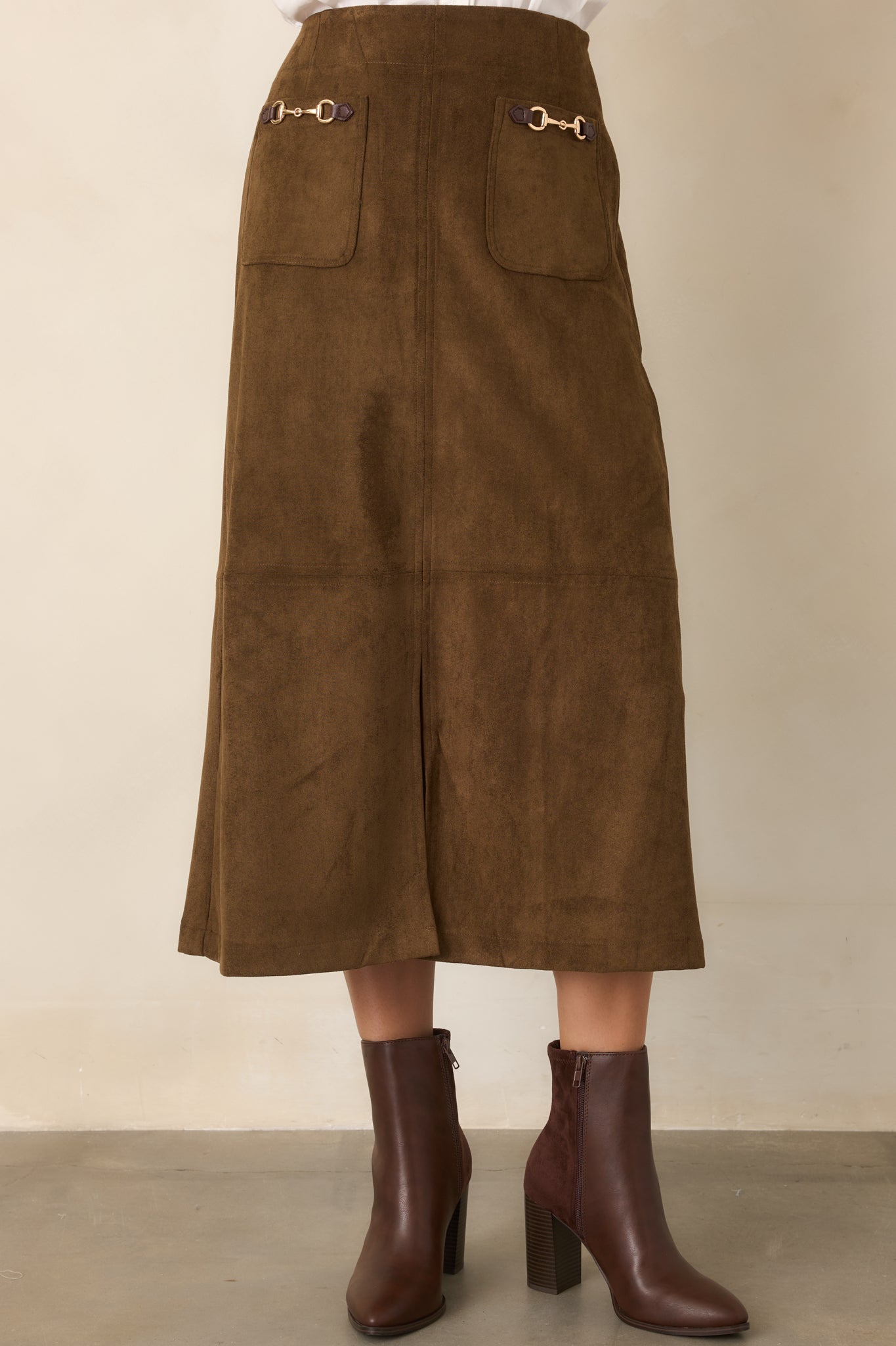 Tailored skirt displaying the structured silhouette, gold-tone horse-tack hardware, and center-front slit.