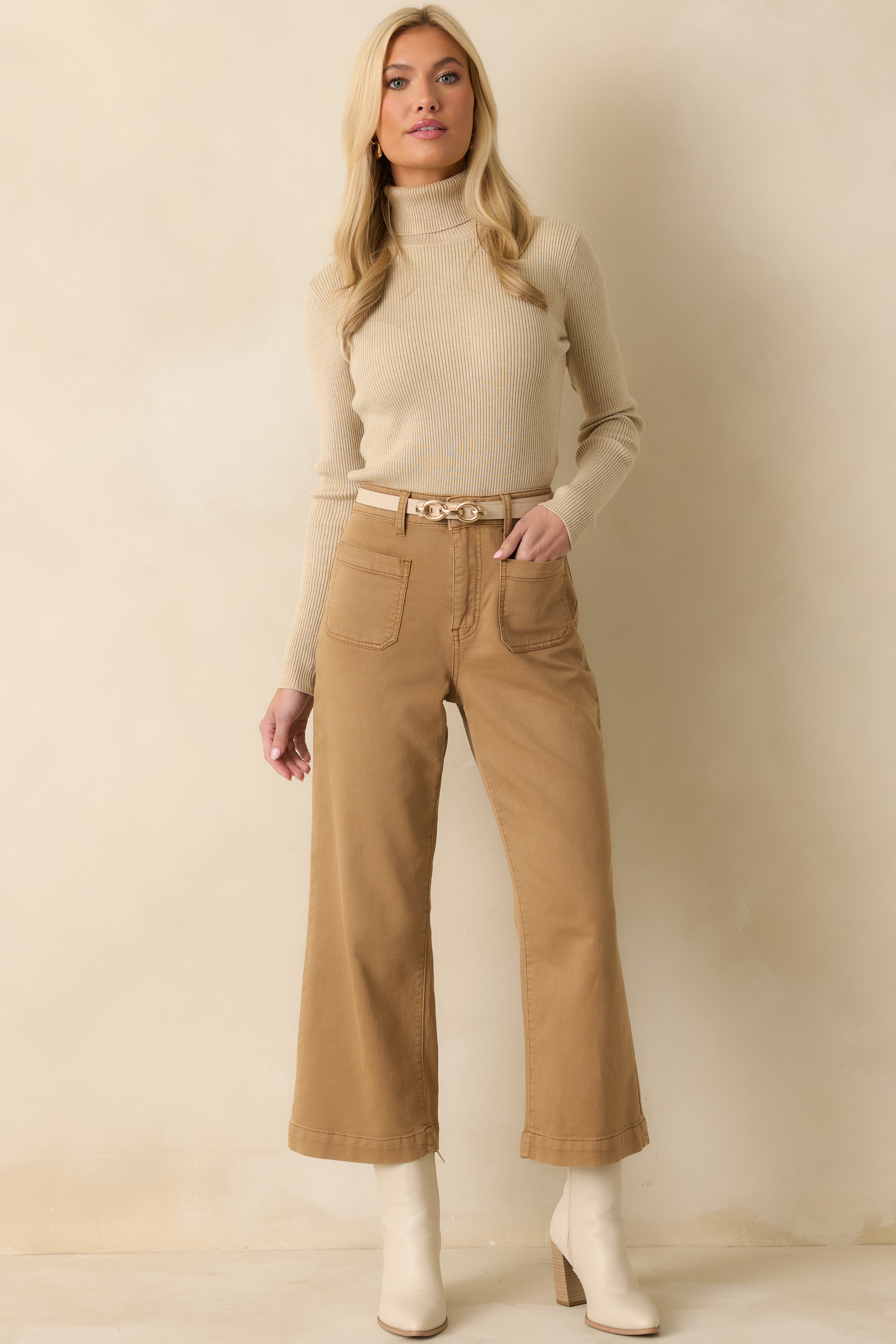 Tan brown pants shown from the front, featuring a high rise waist, wide leg silhouette, and cropped length.