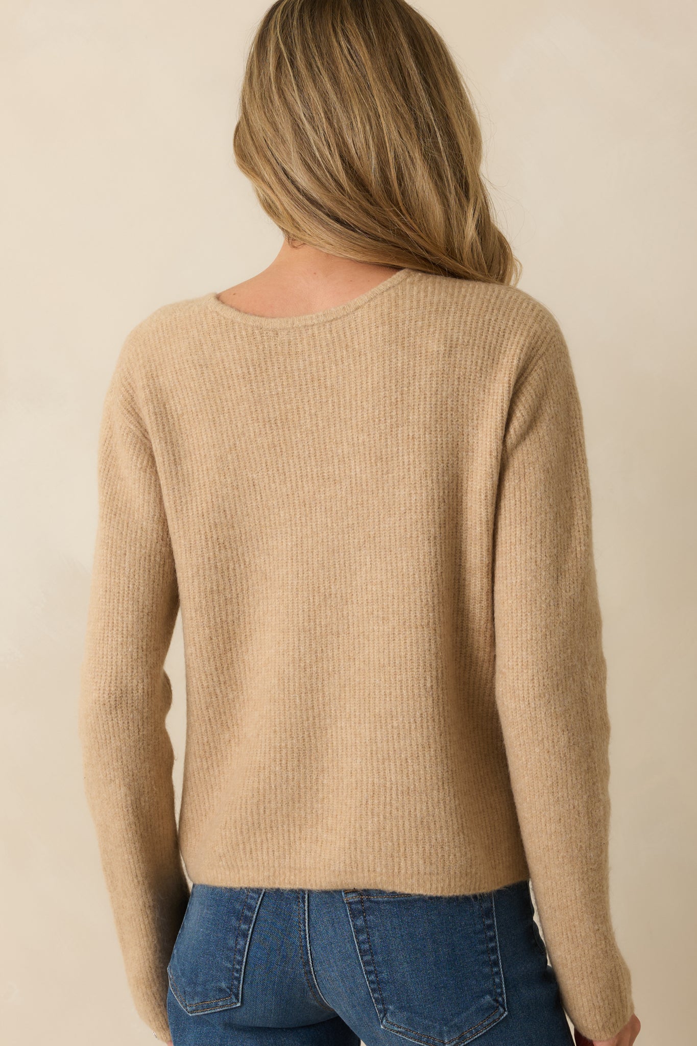 Rear view of the tan cardigan showing the smooth ribbed knit and relaxed silhouette.