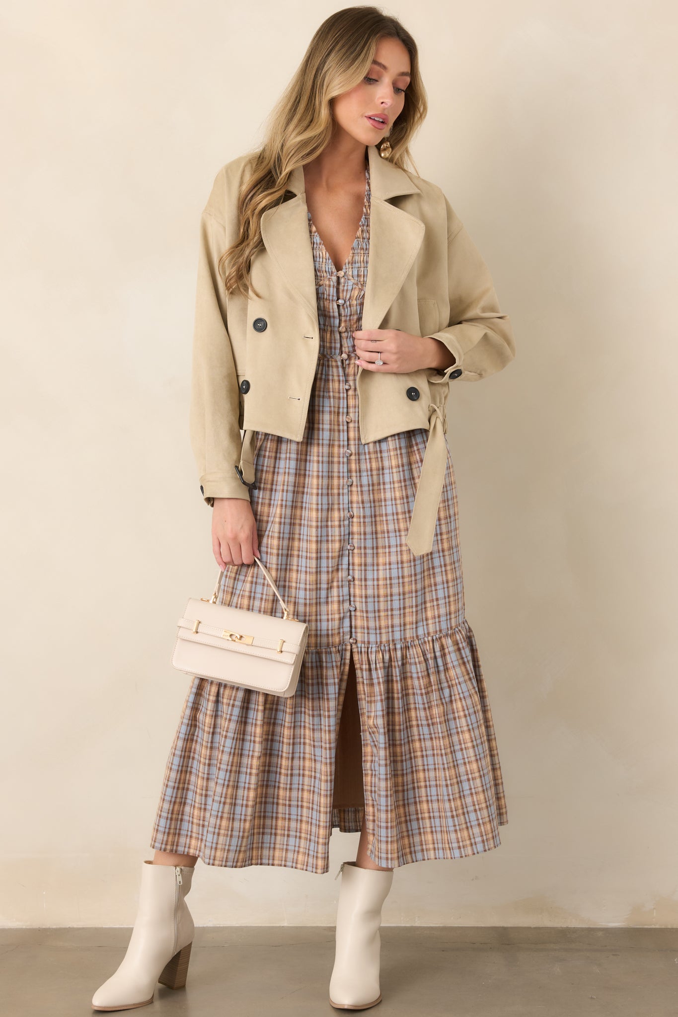 Tan cotton cropped jacket featuring a double-breasted four-button front, notched lapels, long sleeves, and functional side pockets.