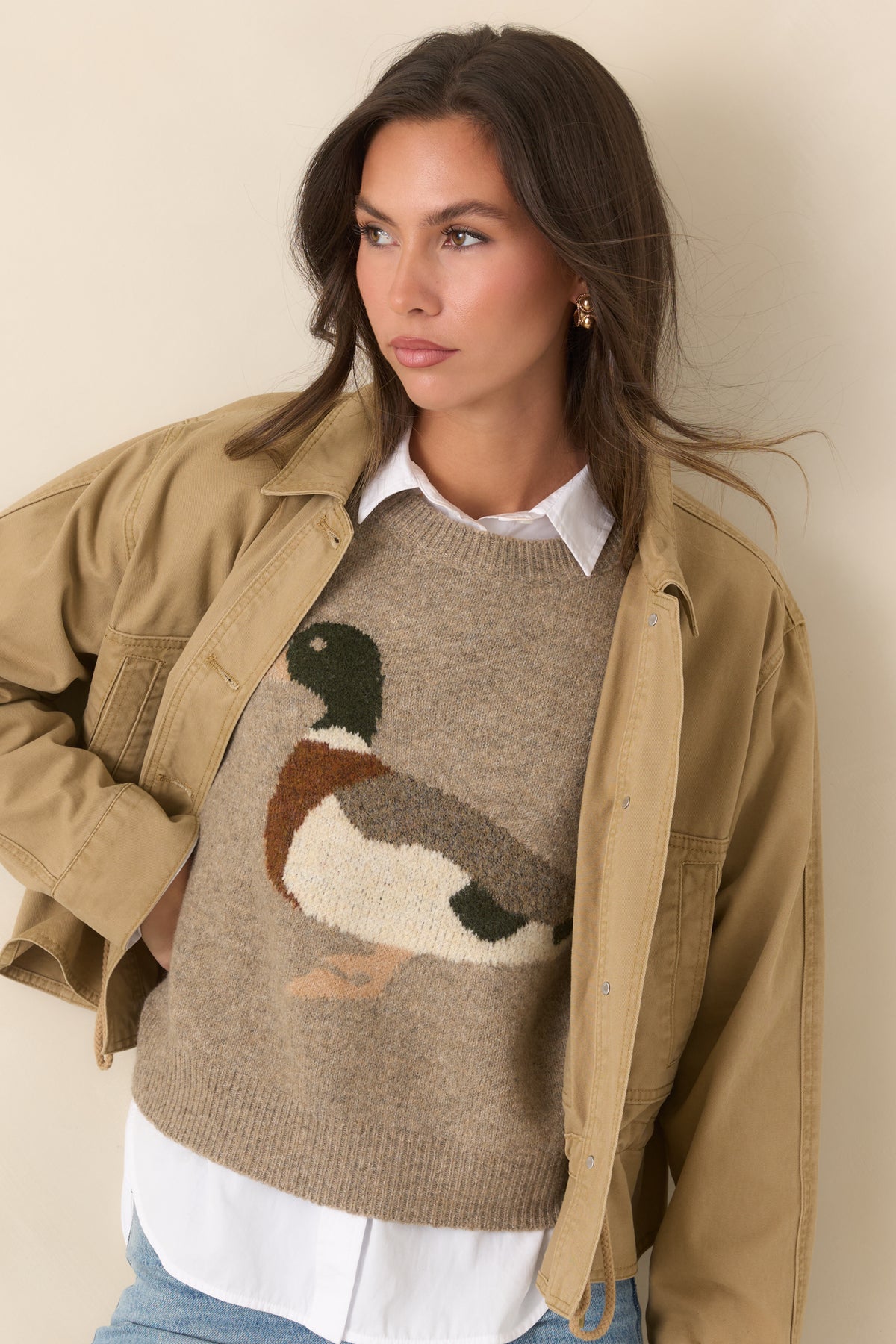 Tan jacket highlights its pointed collar and neat row of front button closures.