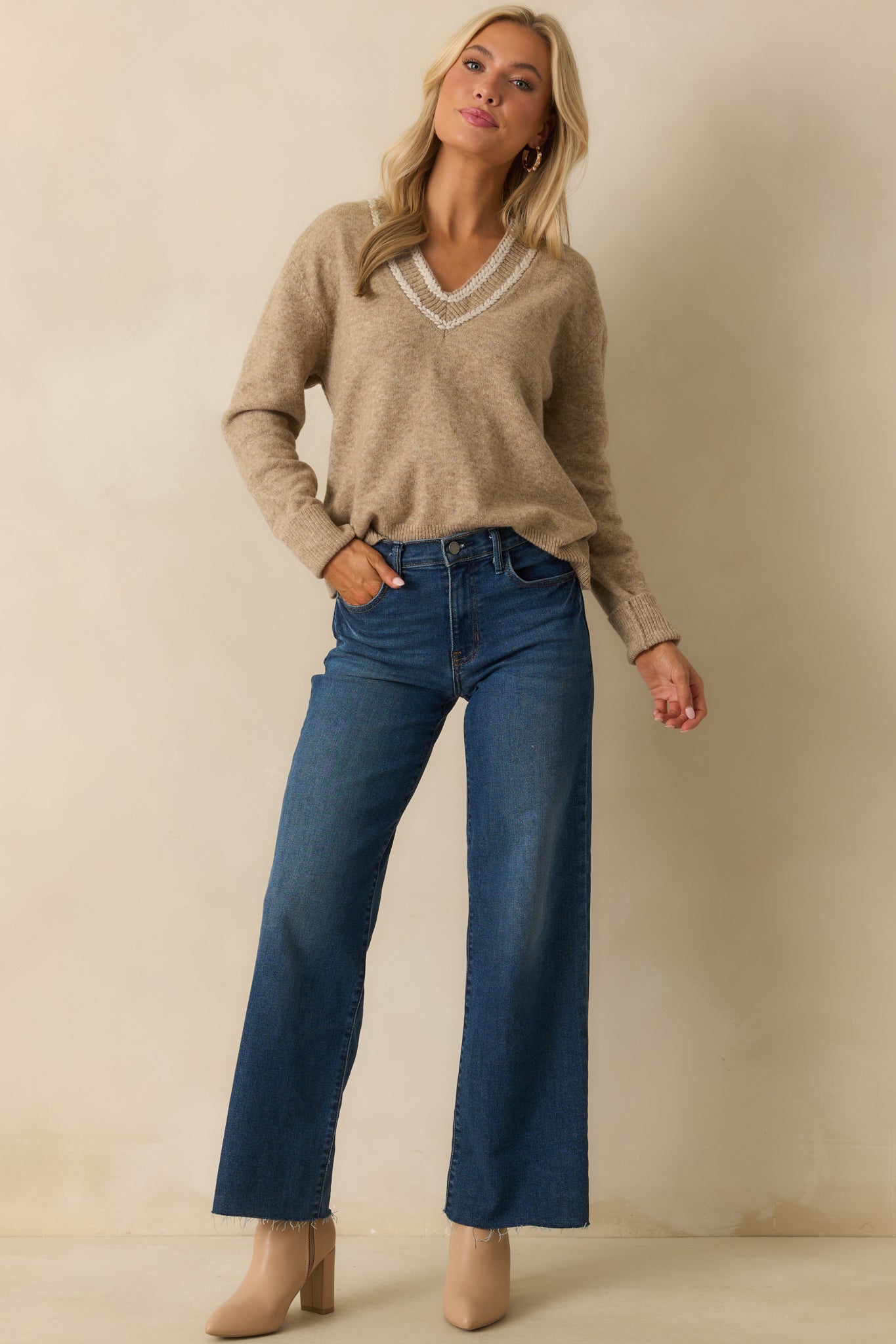 Tan knit sweater with a relaxed silhouette and long sleeves featuring ribbed cuffs.
