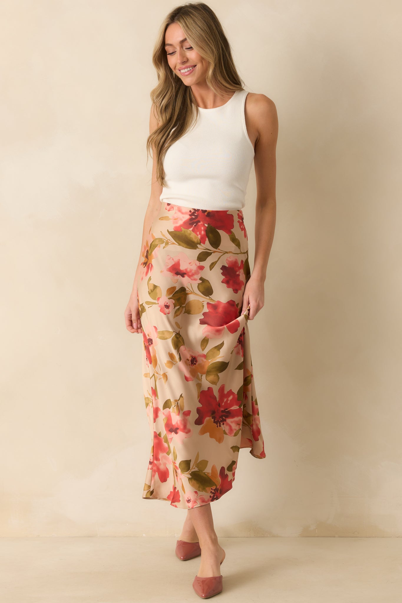 Flowing tan skirt featuring a soft floral pattern and smooth, floor-length silhouette.