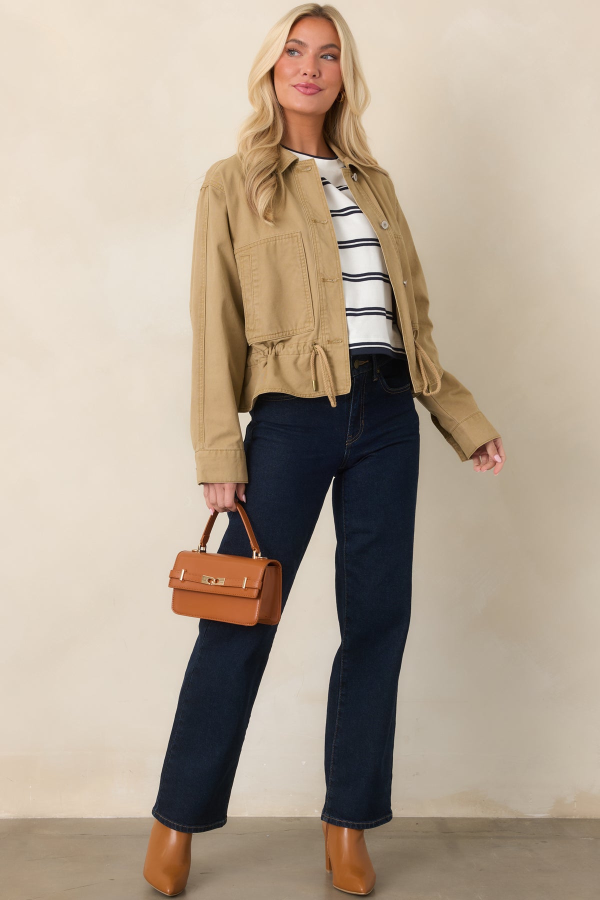 Tan utility jacket featuring a classic collar, button-front closure, large patch pockets, and relaxed silhouette.