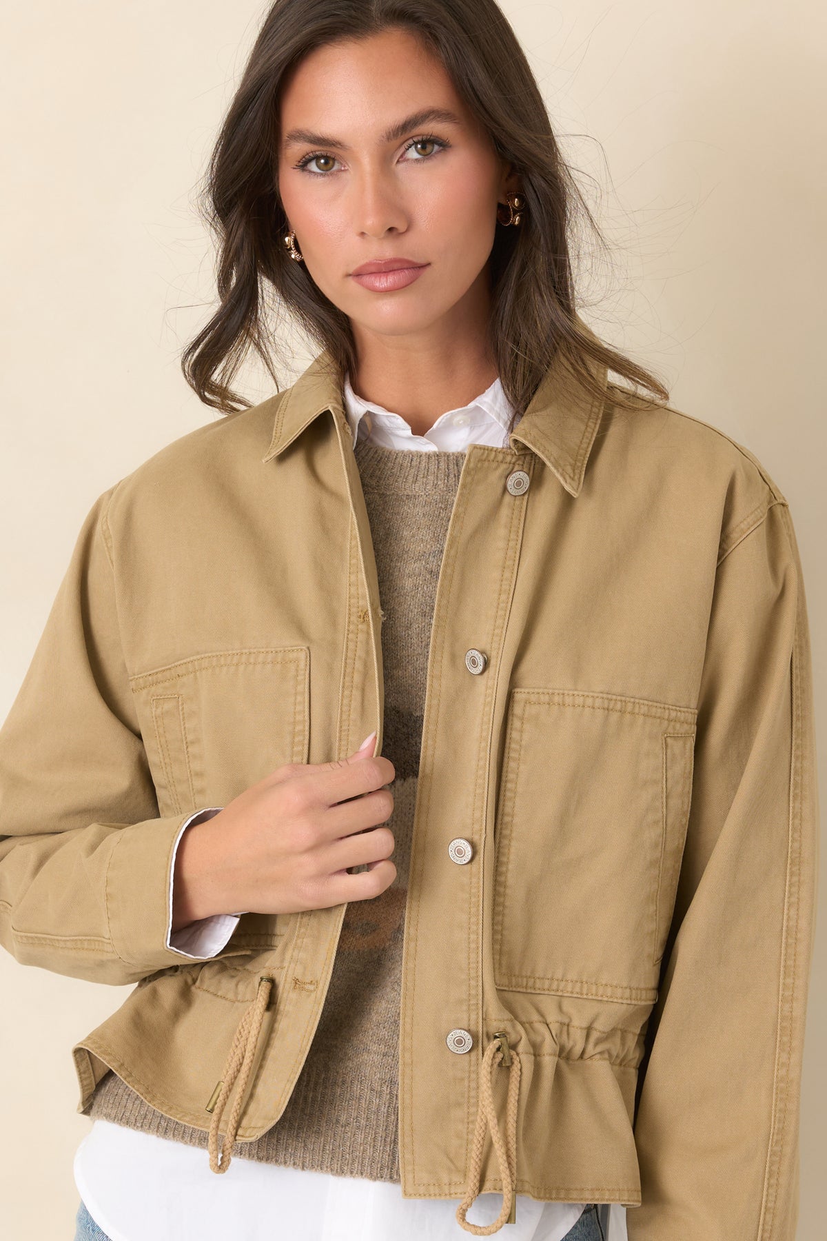 Long sleeves with button cuffs complement the sturdy woven fabric of this tan jacket.