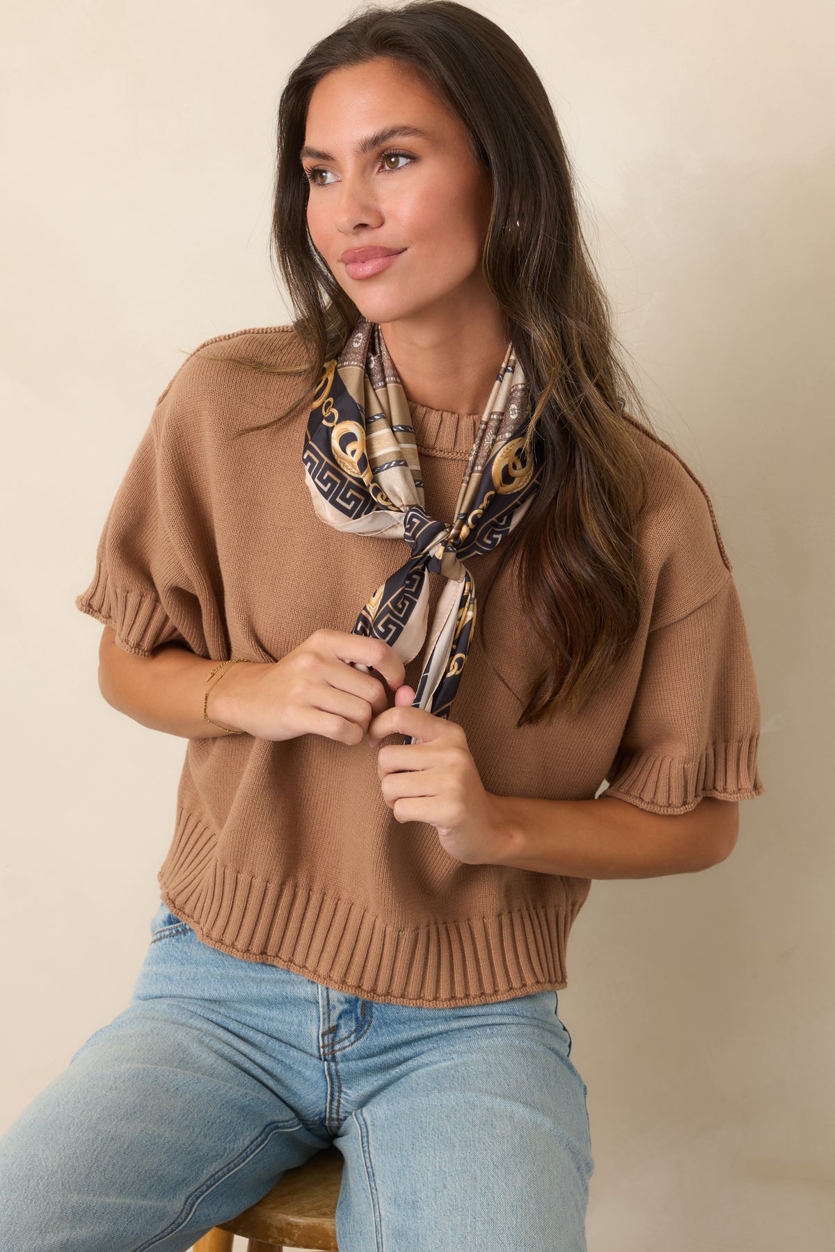 Silky square scarf features taupe, camel, black, and gold tones with chain motifs and geometric borders.