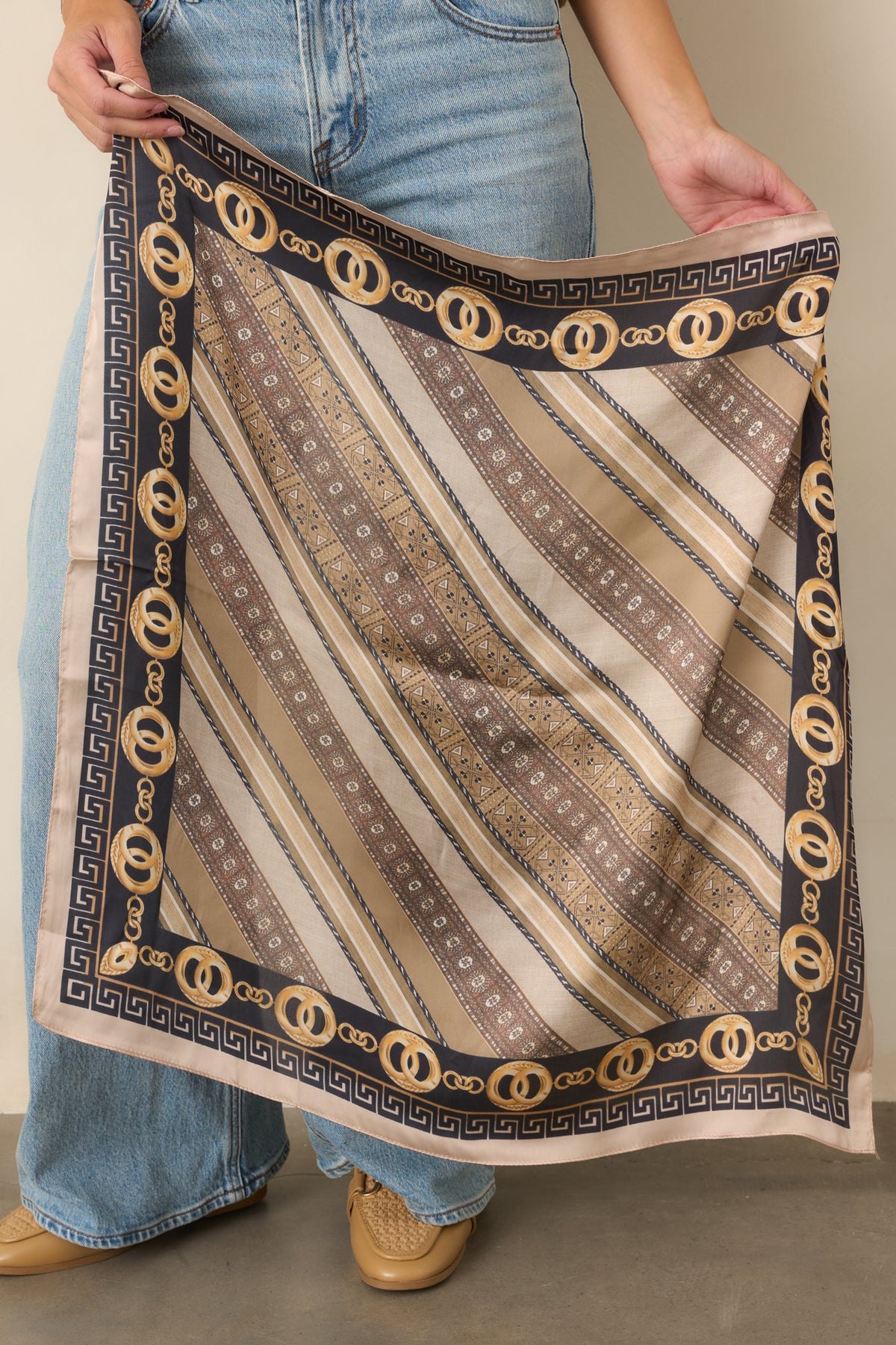Taupe and camel scarf print combines black accents, gold details, and repeating chain motifs.