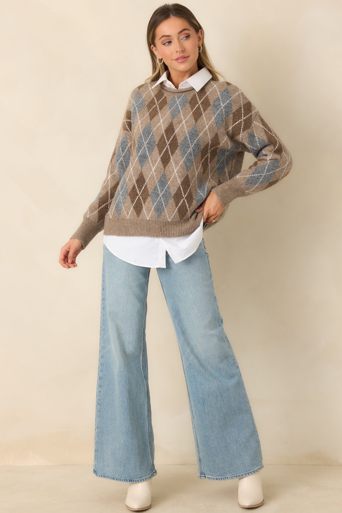 Relaxed taupe and cream argyle sweater featuring a rolled-edge round neckline and dropped shoulders.