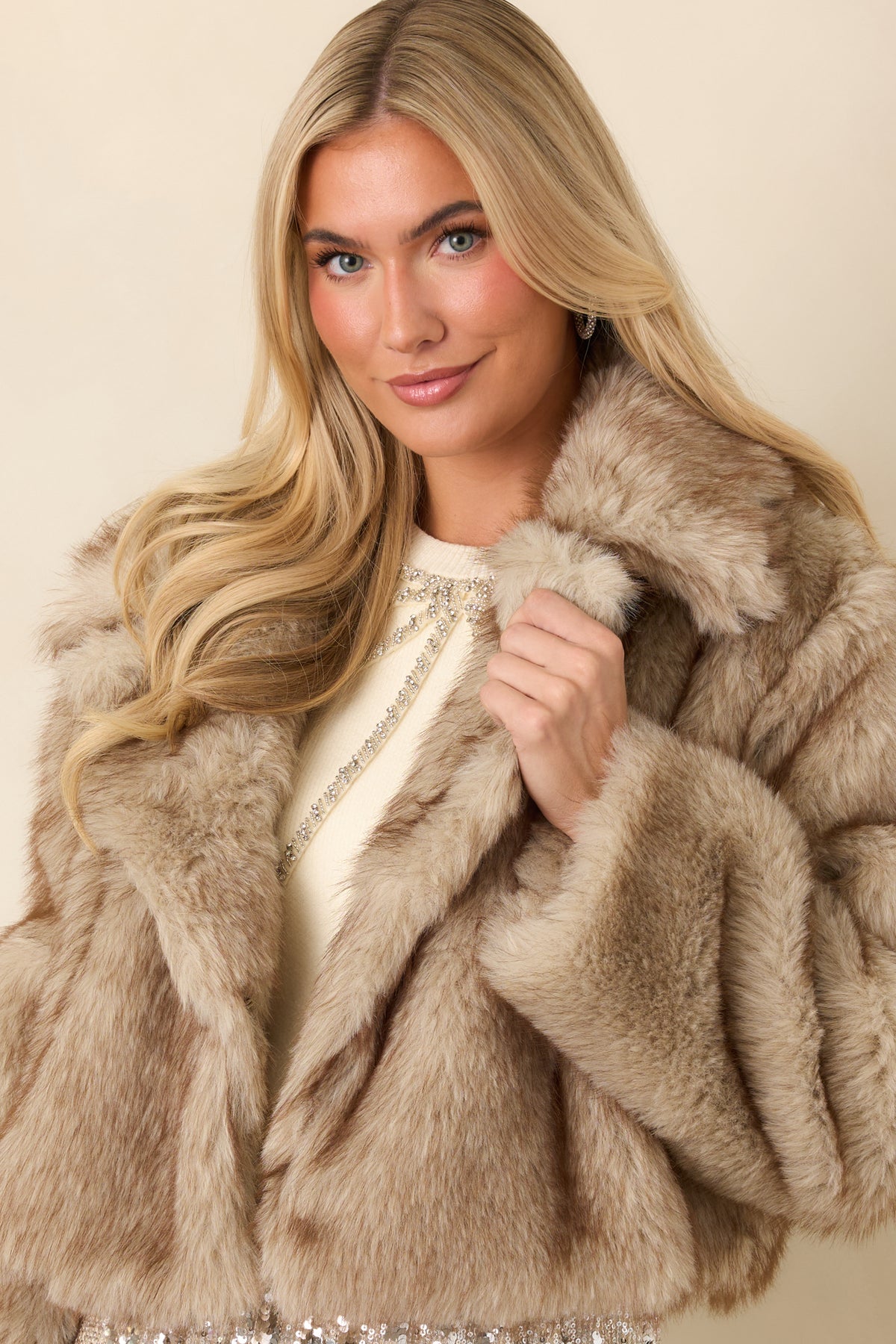 Long sleeves and soft, multitone faux fur texture on the cropped taupe jacket.