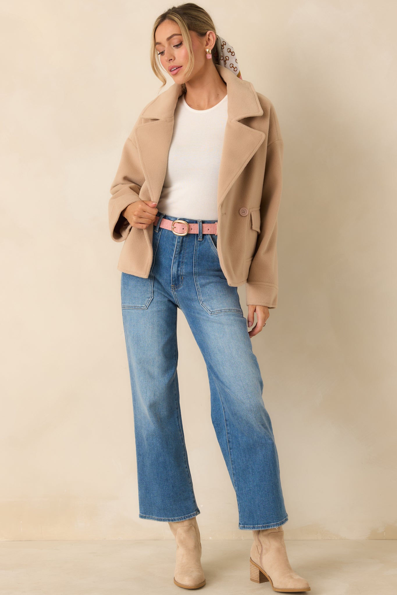 Cropped-silhouette taupe jacket with double-breasted buttons and tailored front flap pockets for layering.