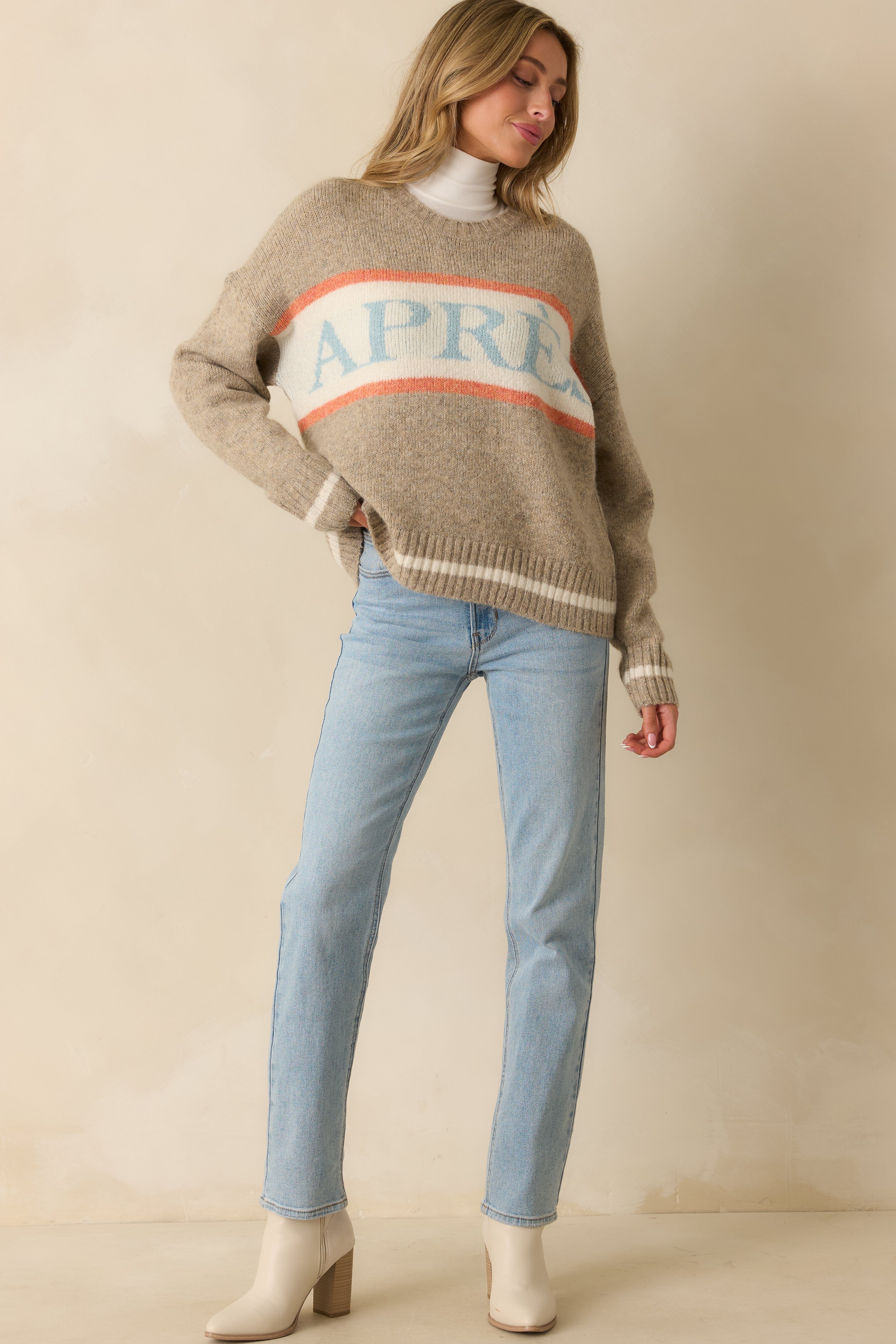 Cozy taupe sweater with light blue “APRÈS” lettering, soft knit fabric, and relaxed long-sleeve silhouette.