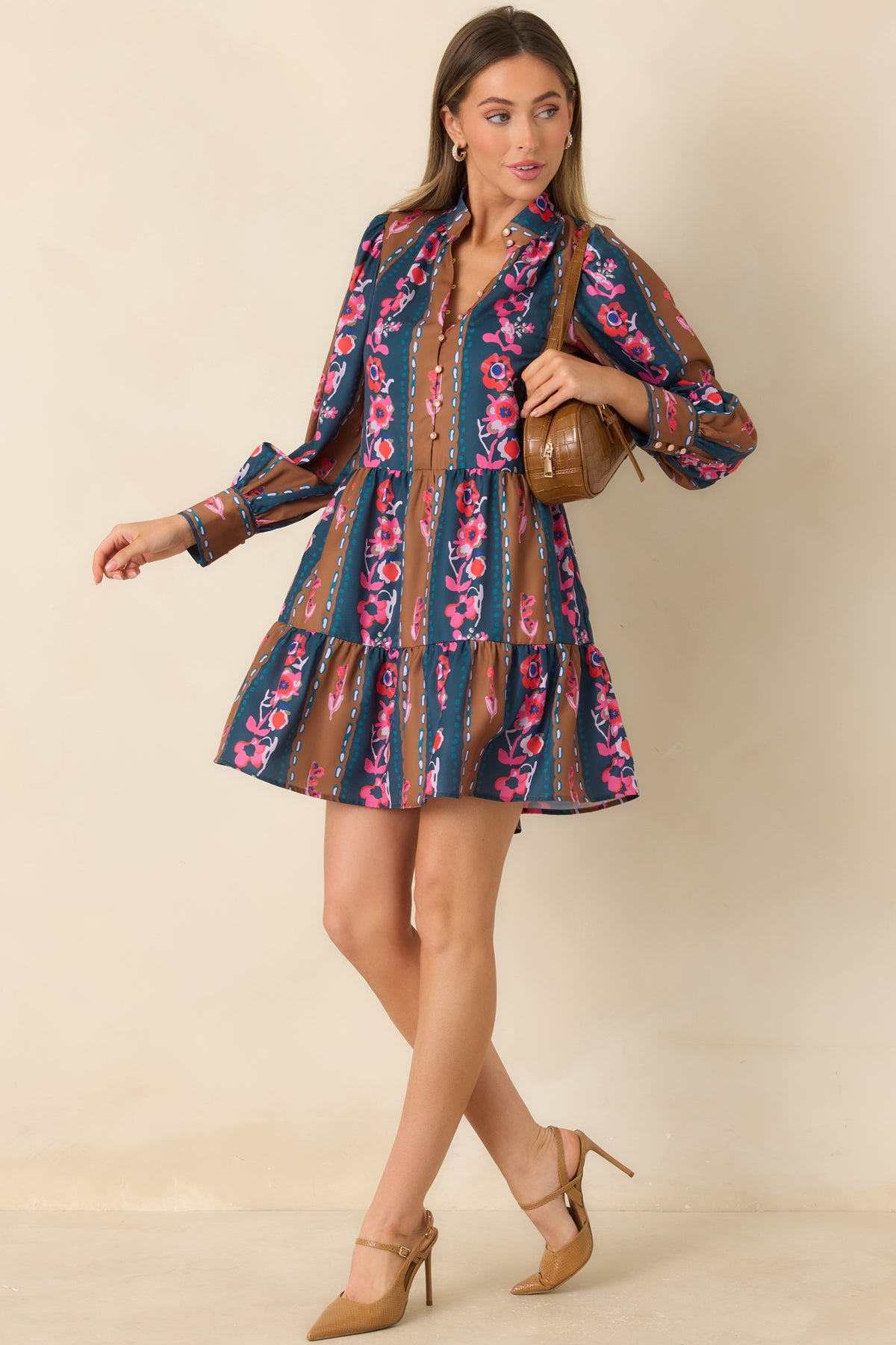 Deep teal and warm caramel mini dress with multicolored blooms, softly gathered sleeves, and a tiered skirt.