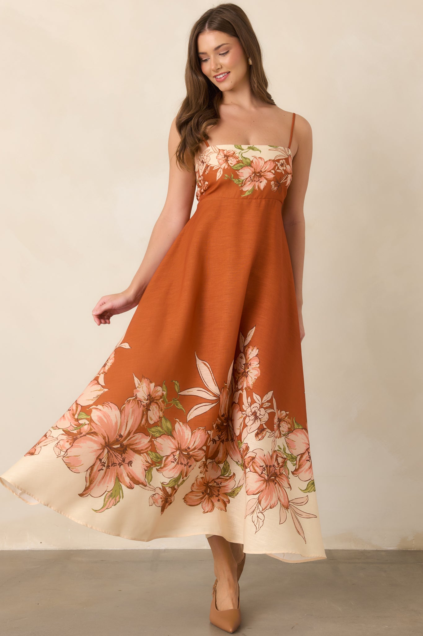 Terracotta maxi dress featuring slim adjustable straps, a straight neckline, fitted bodice, and softly flowing empire-waist skirt.