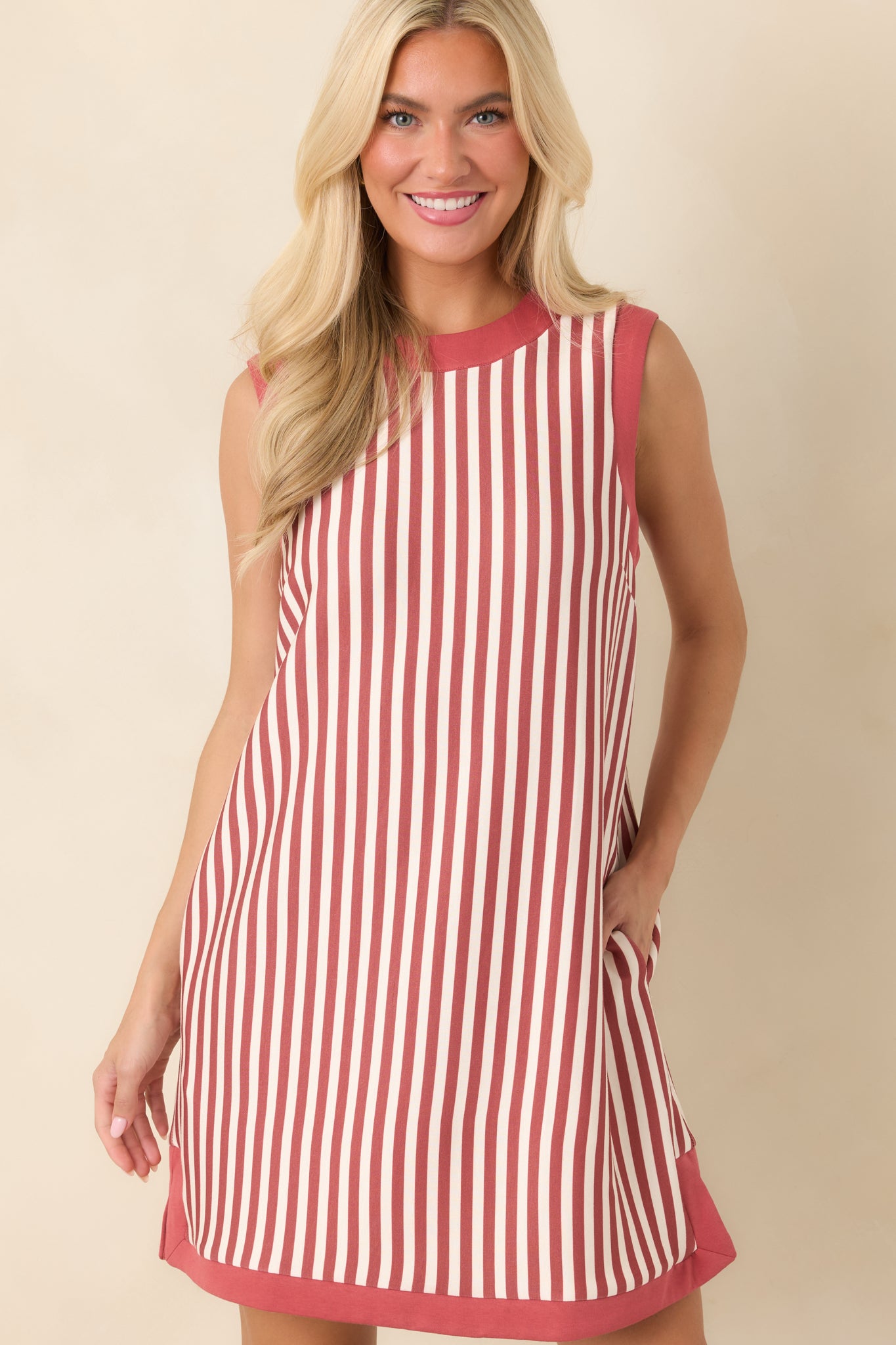 Upper portion of the sleeveless dress showcasing its vertical stripe pattern, rounded neckline, and clean terracotta edging.
