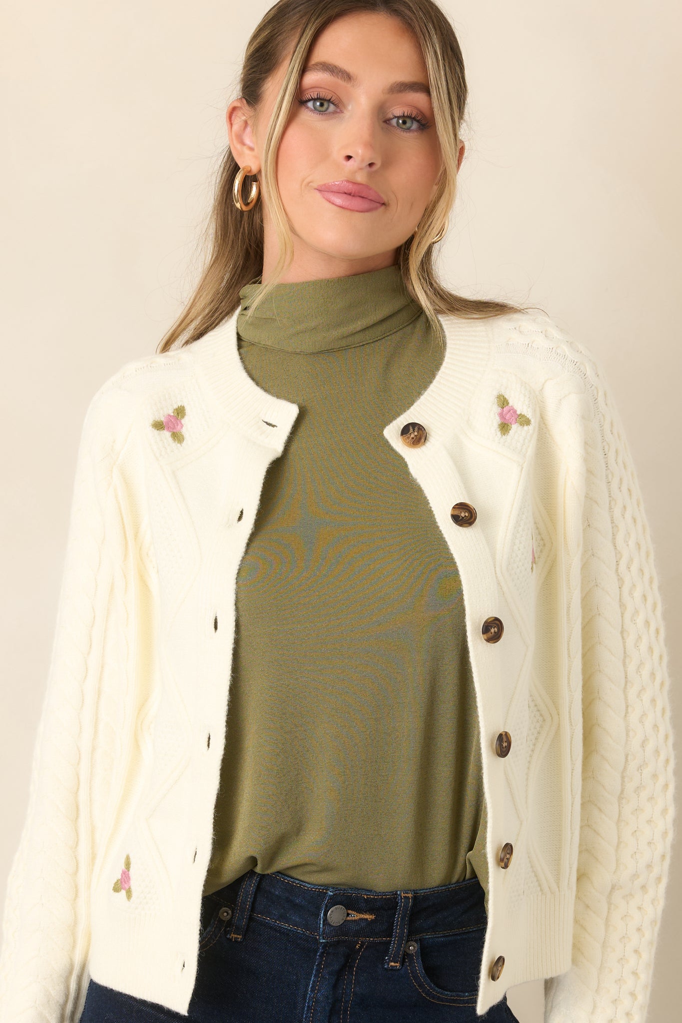 Textured cardigan showcasing the round neckline, scattered floral embroidery, and ribbed trim along the front edges.
