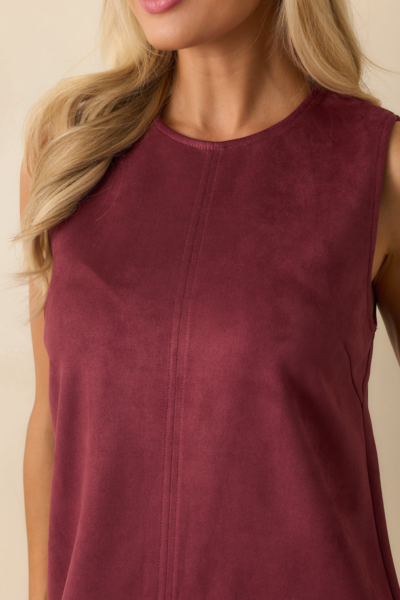 Textured detail showing soft faux-suede top, smooth faux-leather skirt panel, and stitching along the wine red mini dress.