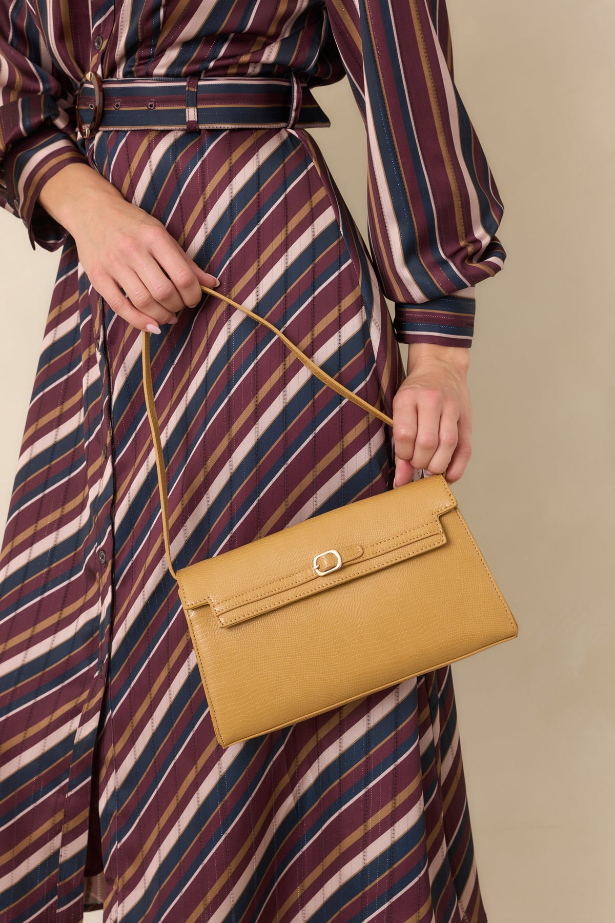 Textured handbag with a sleek envelope-style flap, delicate belt detail, dainty gold-tone buckle, and ultra-thin strap.
