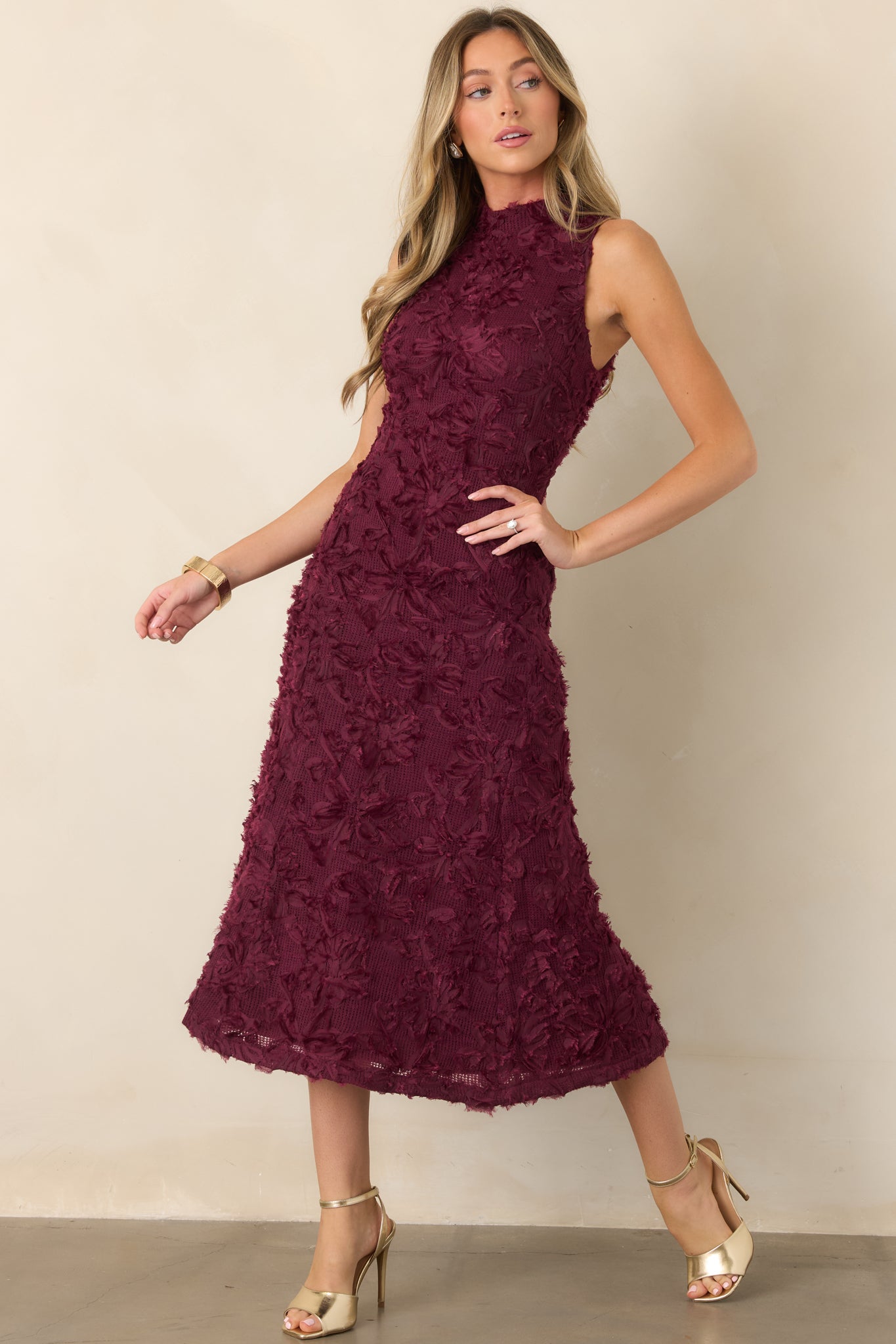 Textured floral appliqué dress featuring a polished high-neck design, fitted waistline, and softly flowing midi skirt.