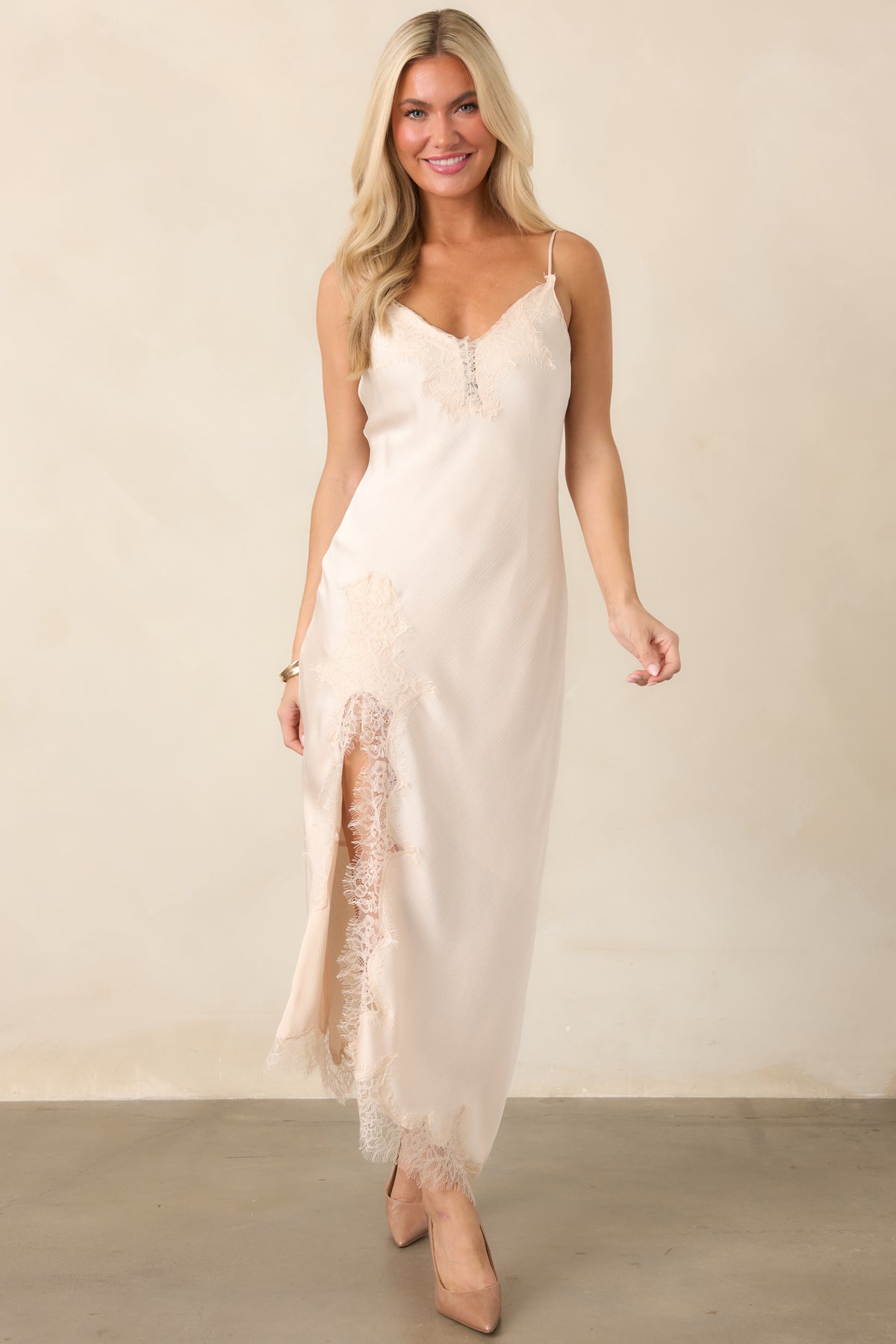 Textured satin midi dress showcasing its fluid bias-cut shape, adjustable spaghetti straps, asymmetrical lace-trimmed hem, and graceful side slit.