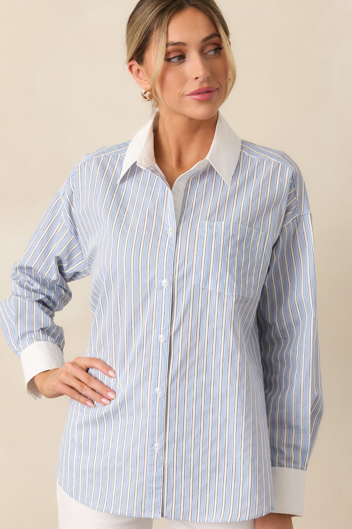 The subtle stripe print and white cuffs bring a refined touch to the relaxed fit of this blue blouse.