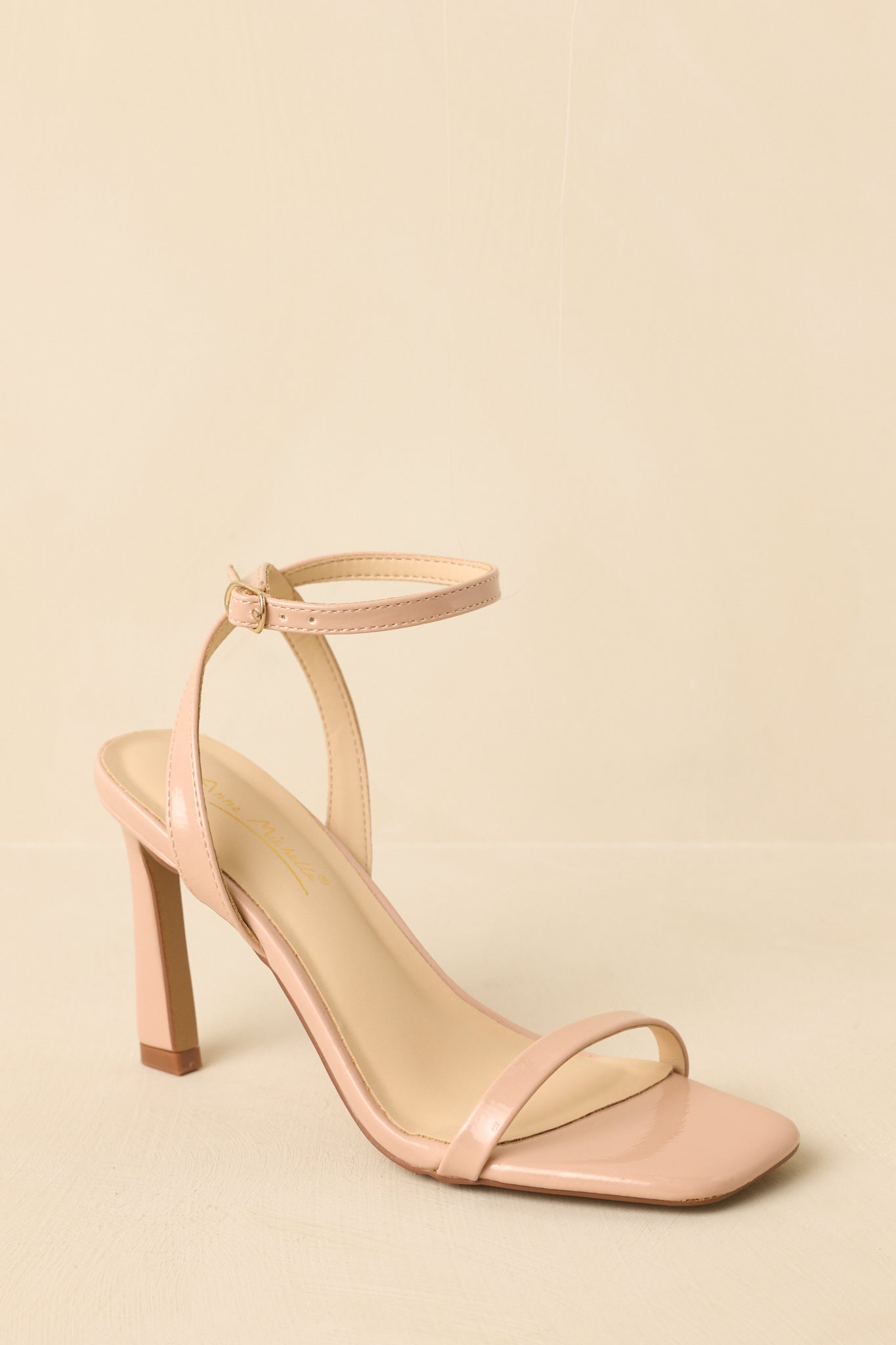 Three-quarter angle view showing the minimalist silhouette and adjustable ankle strap.