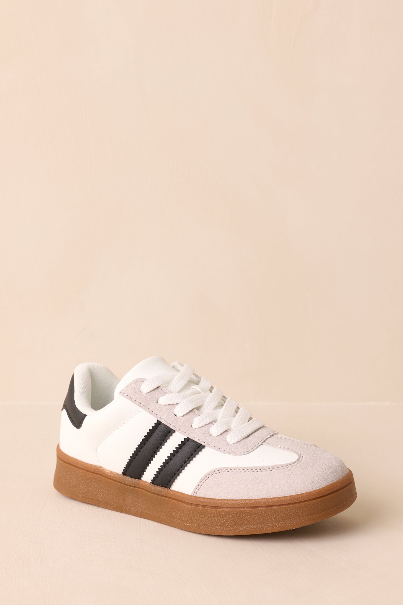 Three-quarter front angle showing the rounded toe, suede texture, and bold black side stripe design.