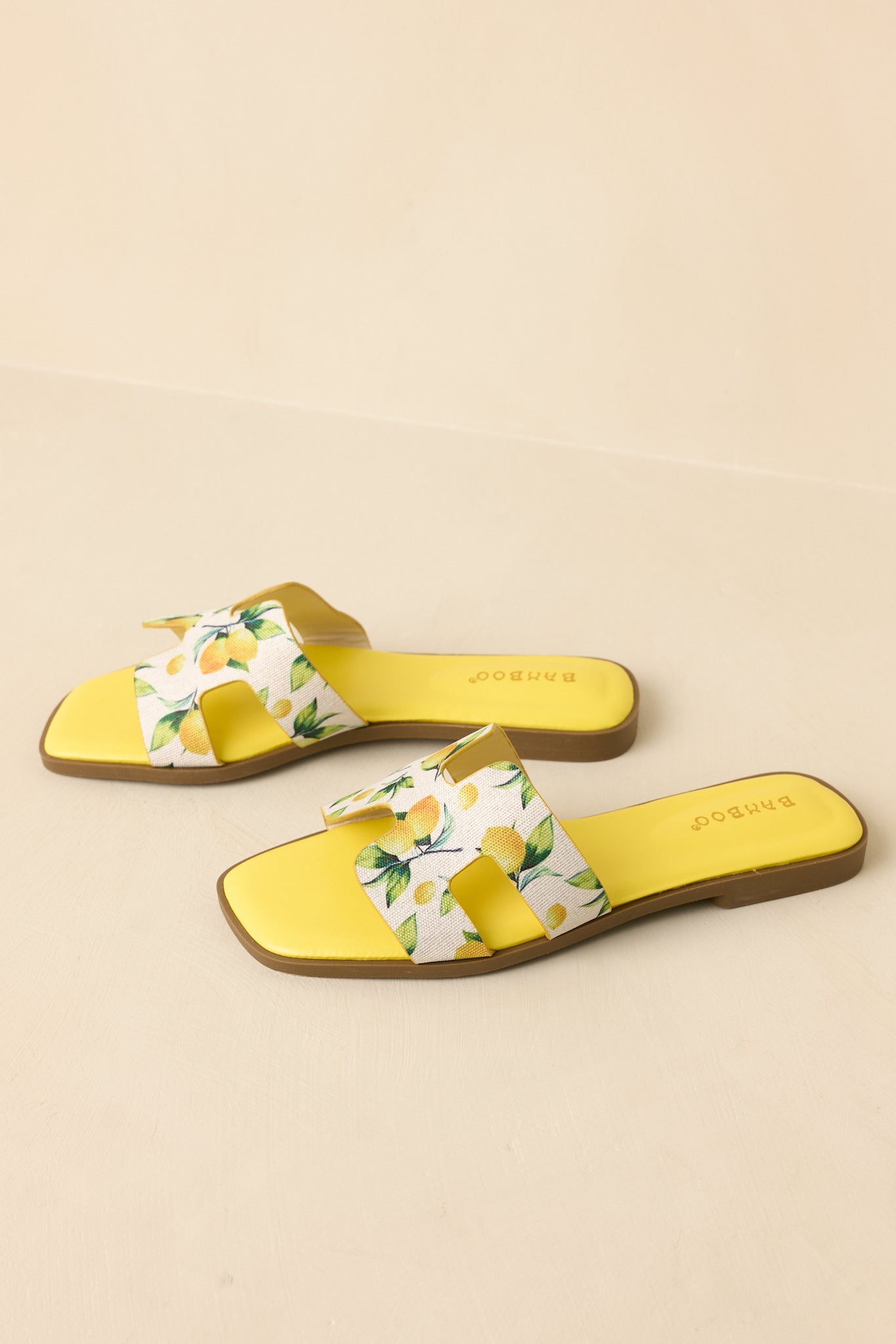 Three-quarter perspective of slide sandals on beige background highlighting lightweight construction and printed strap