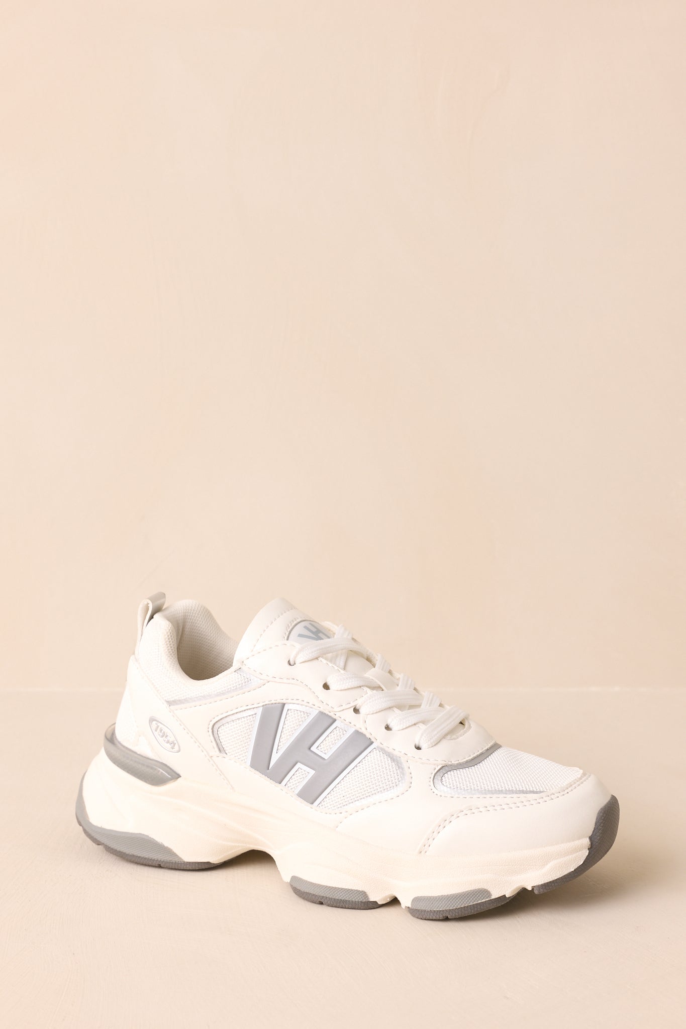 Three-quarter view emphasizing raised “VH” logo on the side, sporty silhouette, and grey-accented sole.