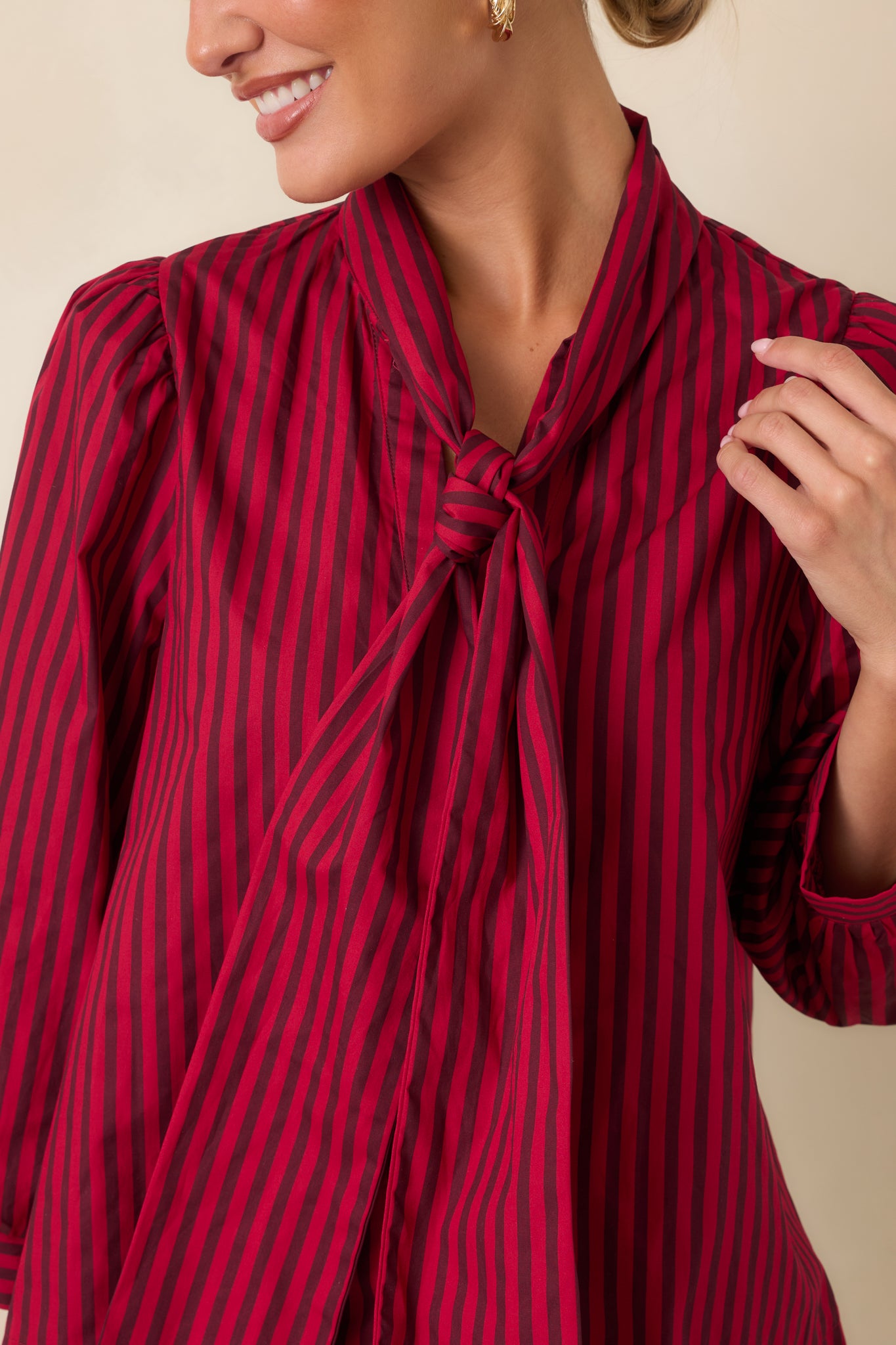 Close-up of the blouse showcasing the self-tie neckline, striped cotton fabric, and button-front detailing.