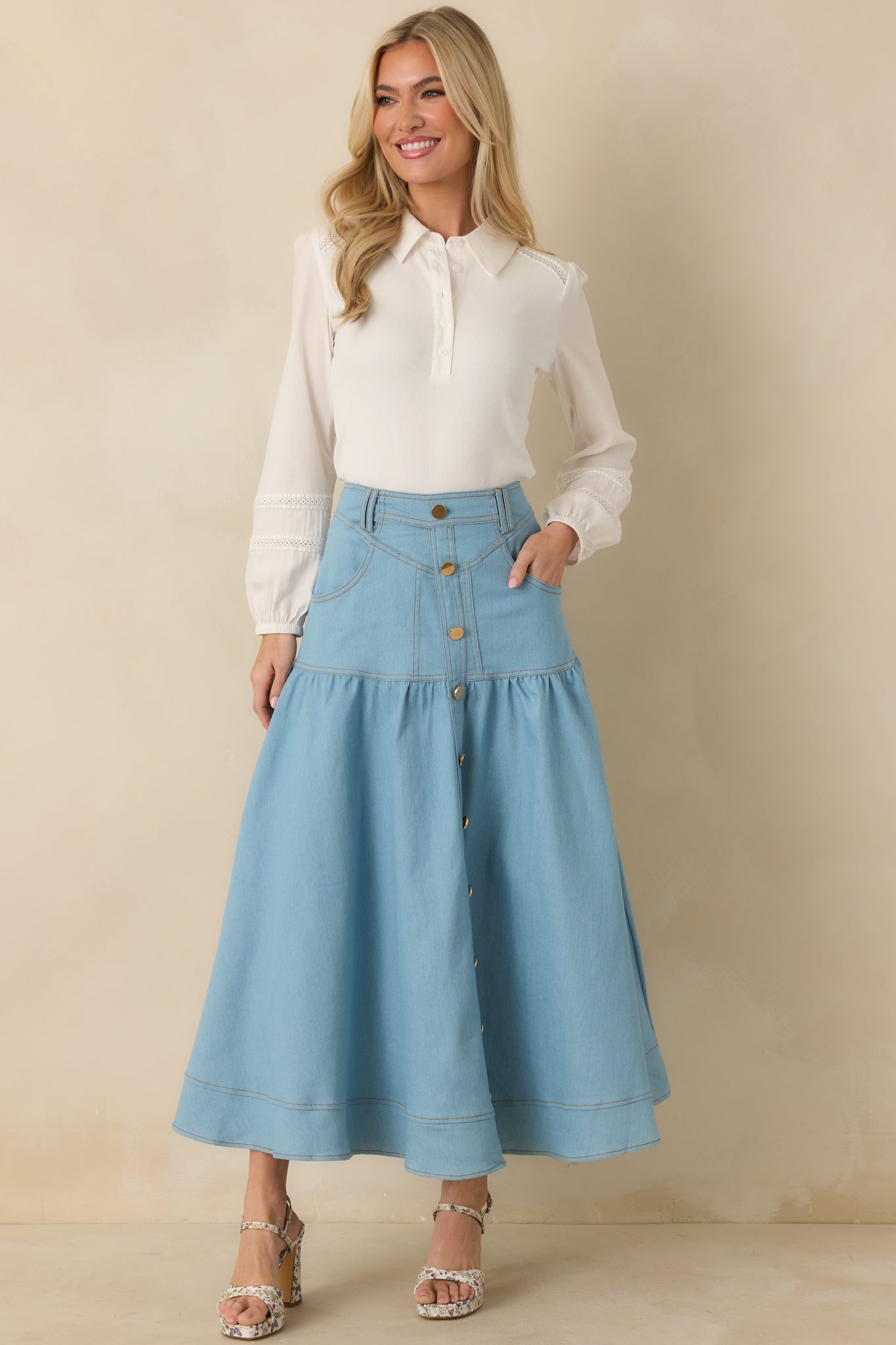Tiered denim maxi skirt in light wash with structured waistband, belt loops, and wide hem for movement.