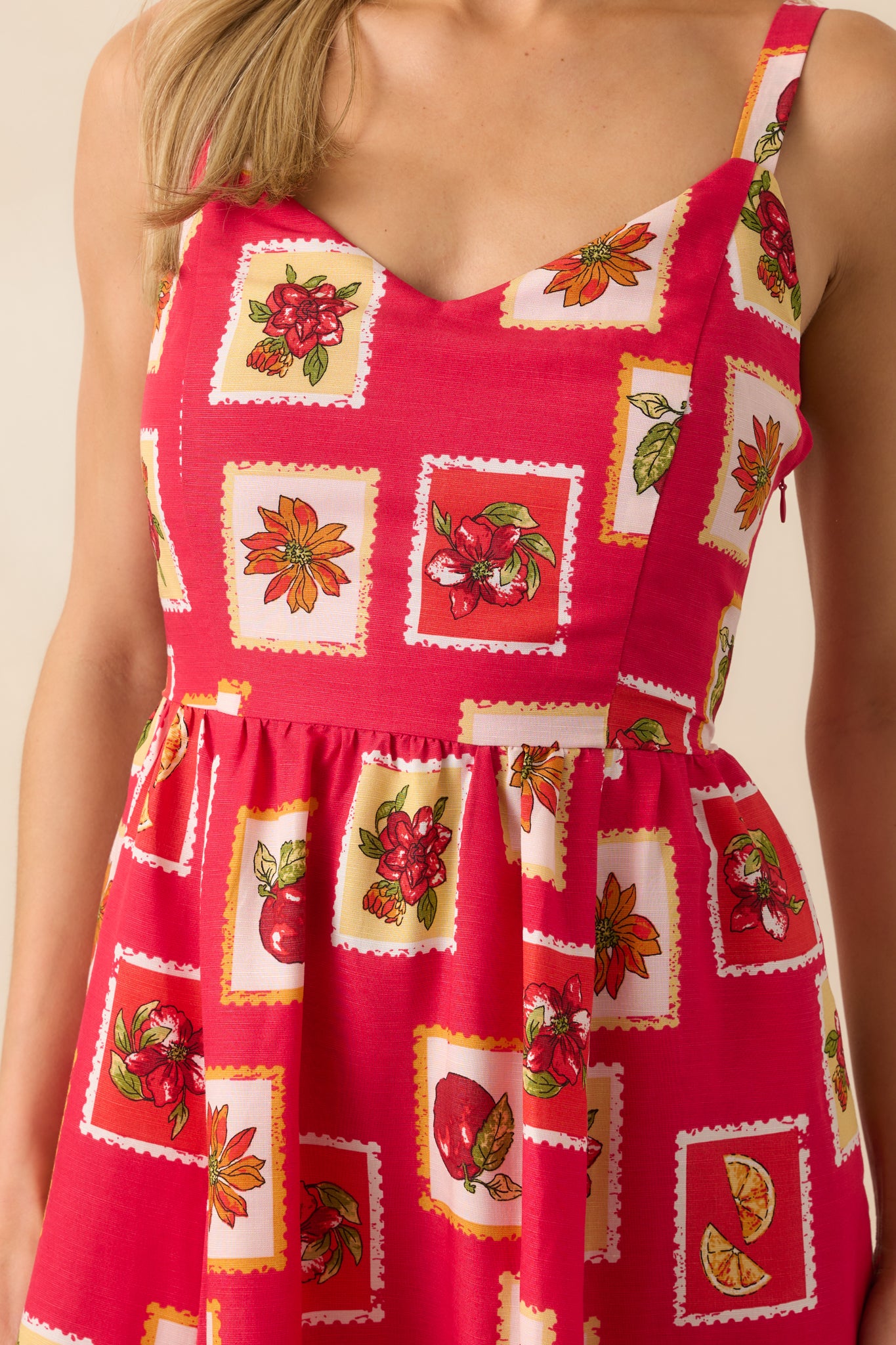 Tight crop showing the intricate floral and fruit patchwork print on the bodice along with the texture of the linen blend fabric.