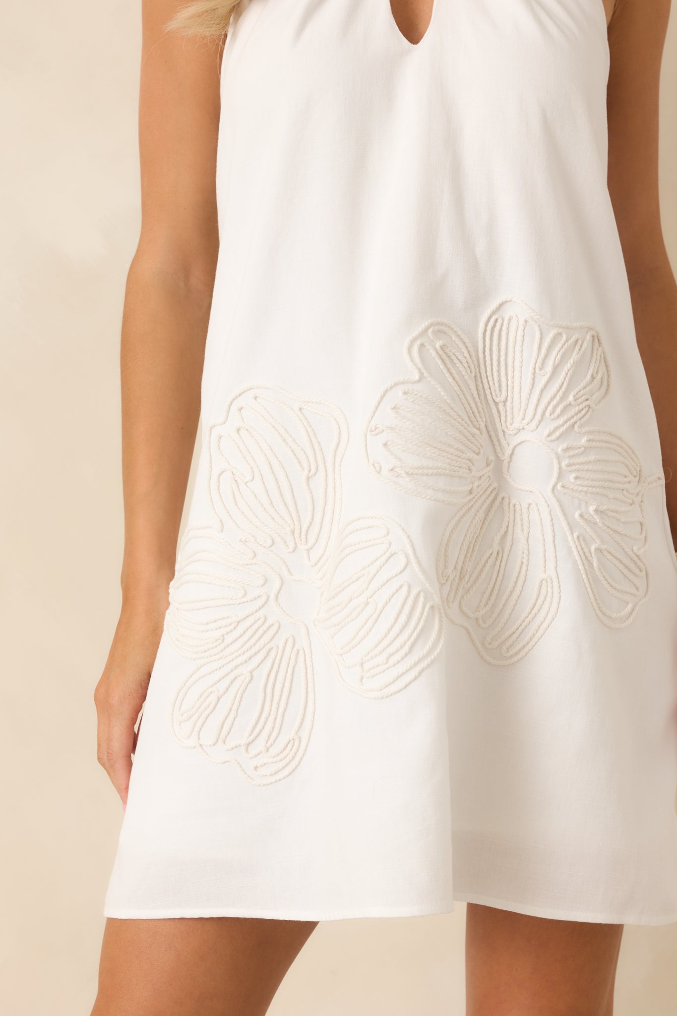 Detailed look at the tonal floral embroidery across the skirt fabric.