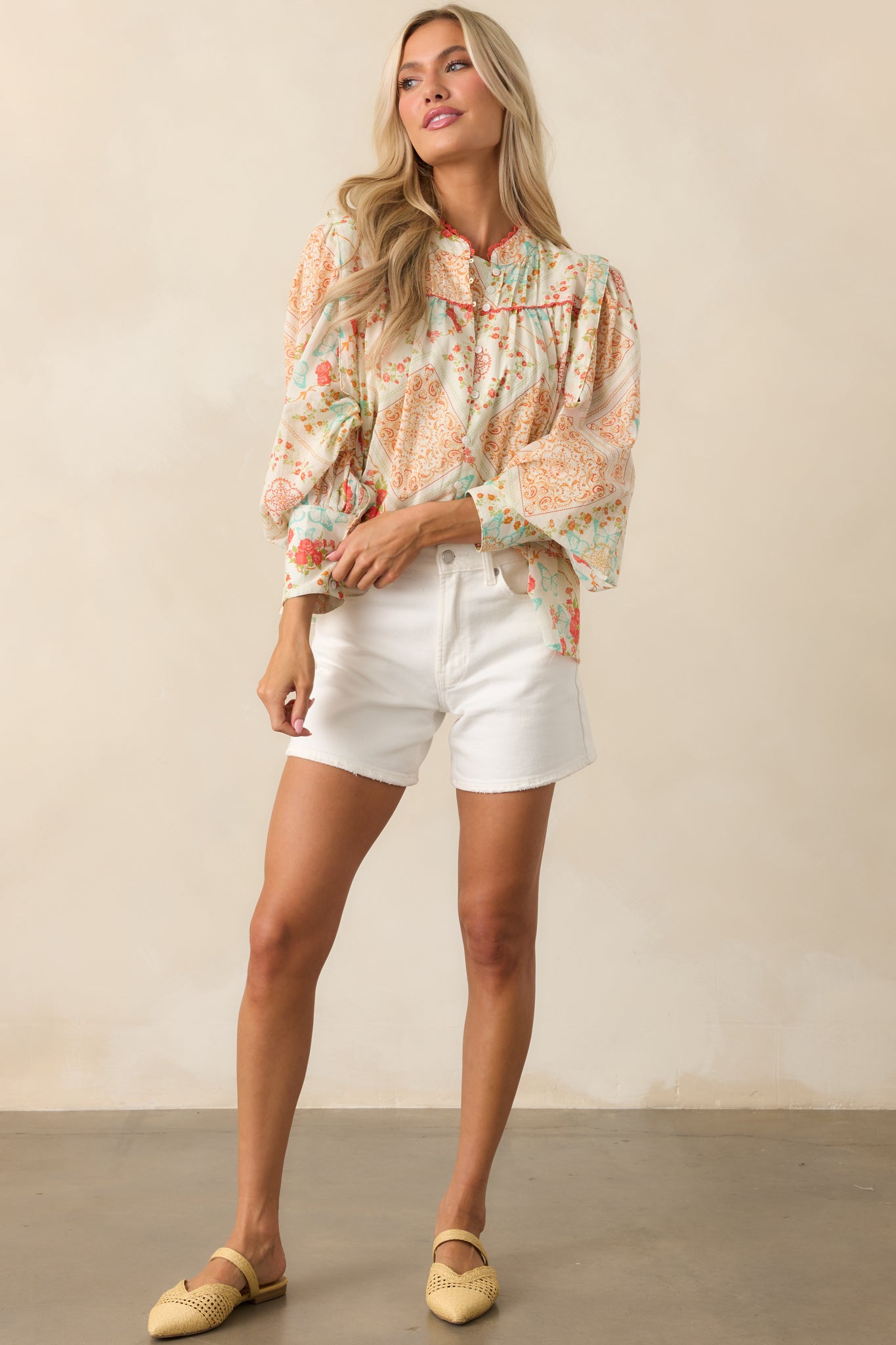 A complete profile of the top highlighting the drape of the long sleeves and the flow of the lightweight fabric.