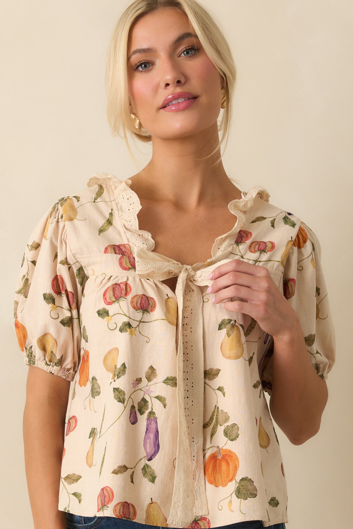 Torso view of ivory blouse with scalloped lace-trimmed neckline and cropped fit.