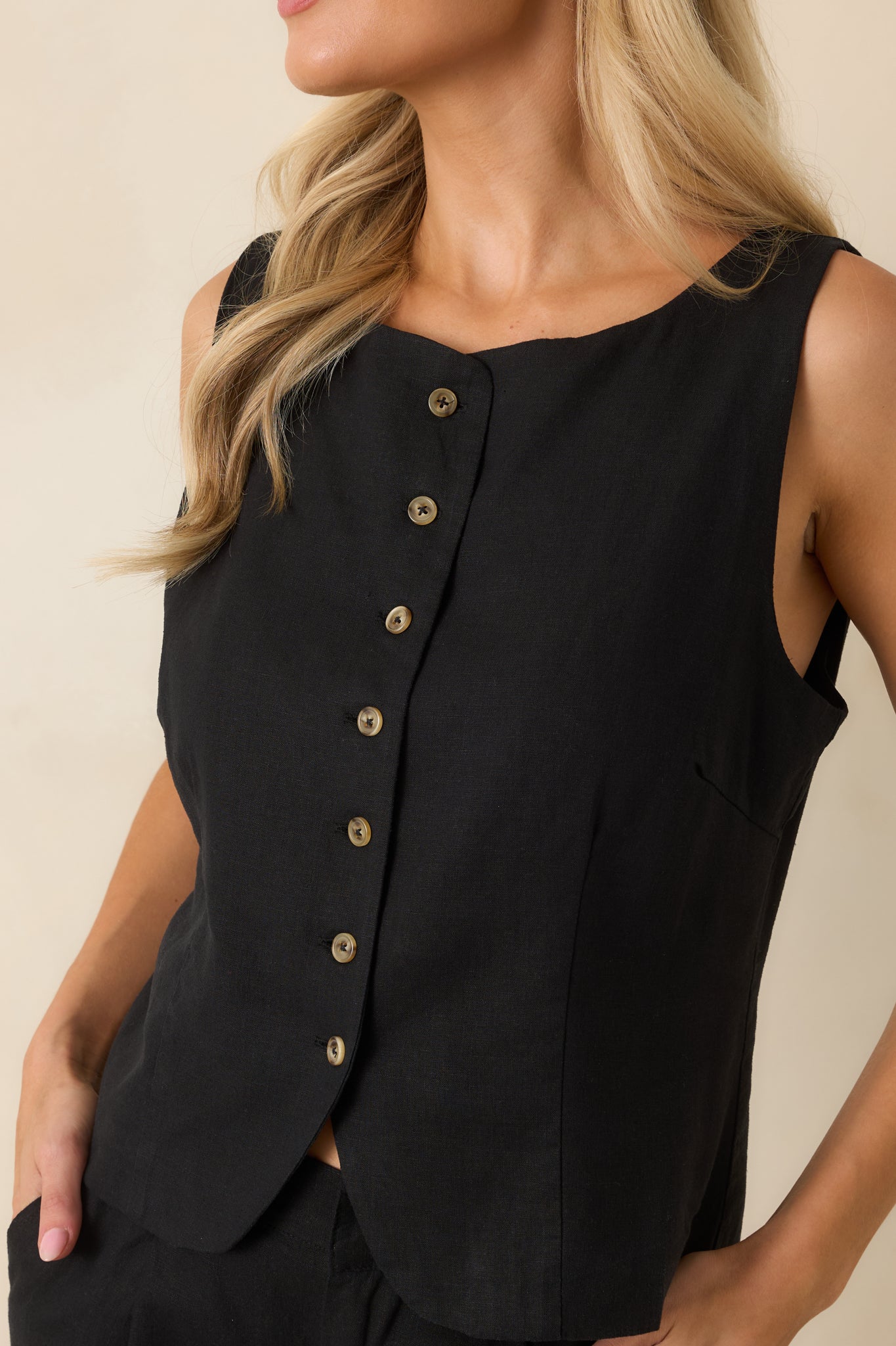 Detailed view of the tortoise-inspired buttons, rounded neckline, tailored seams, and lightweight linen blend fabric.
