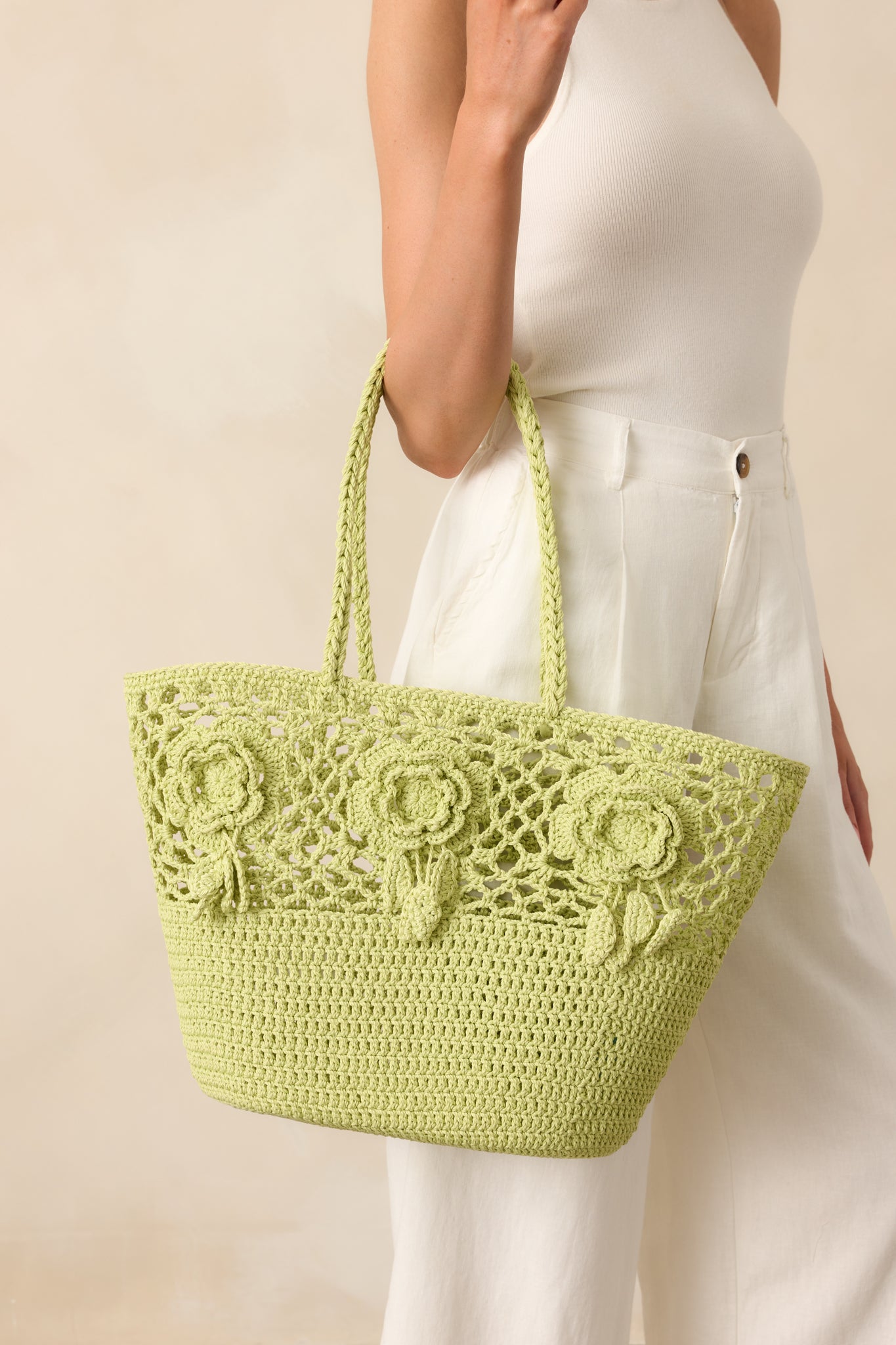A detailed image capturing the 3D woven floral appliqués and the craftsmanship of the structured weave on the tote bag.