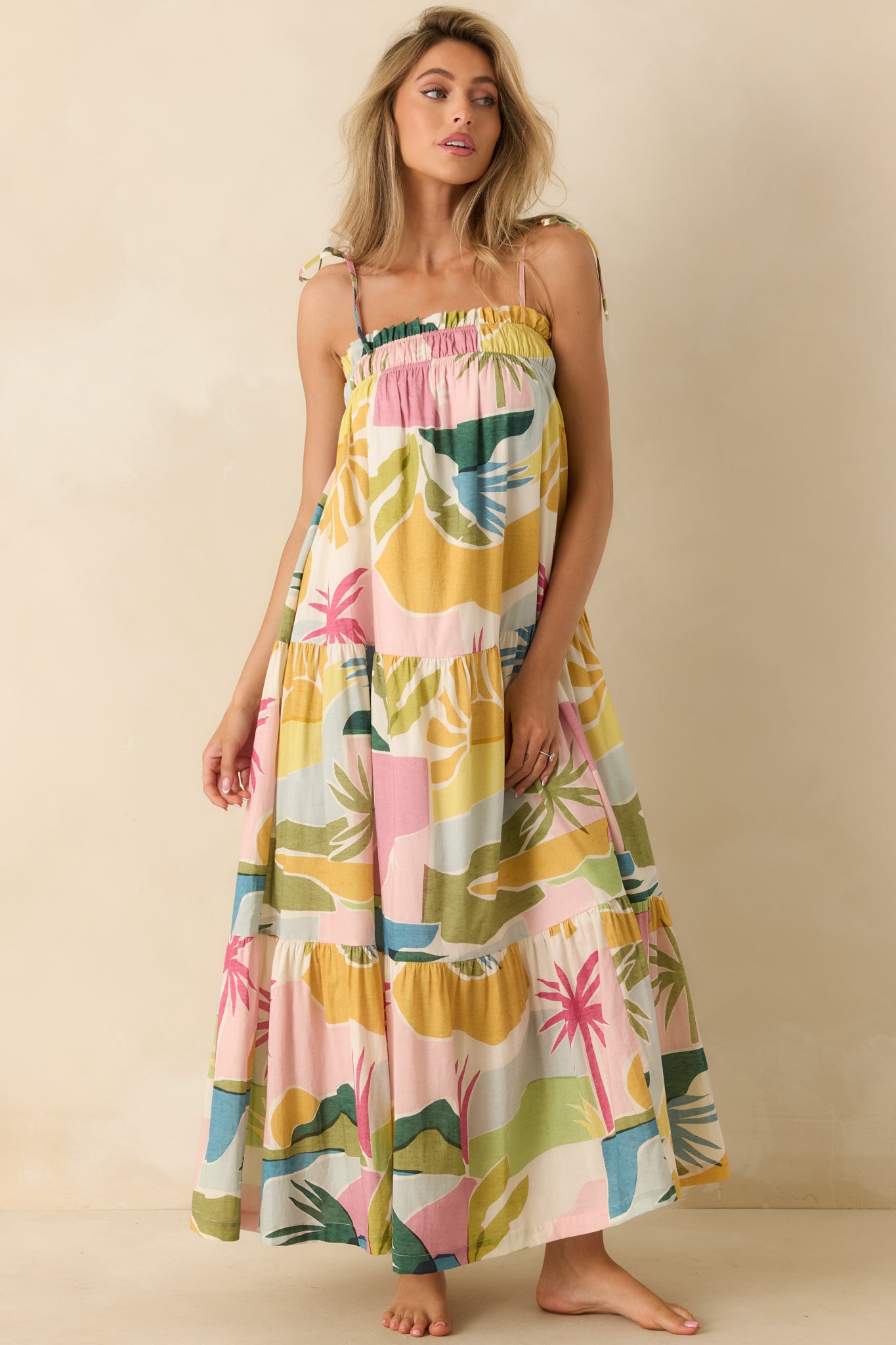 Tropical lagoon maxi dress featuring vibrant multicolor artwork, side pockets, and layered skirt tiers that create graceful movement.