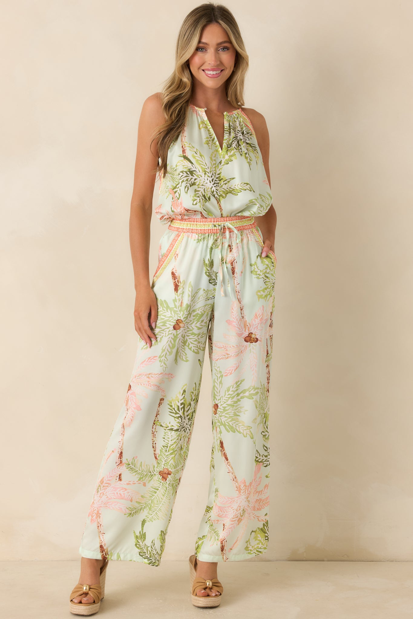 Tropical print sleeveless top in seafoam tones showcasing a front keyhole button closure and easy, airy silhouette.