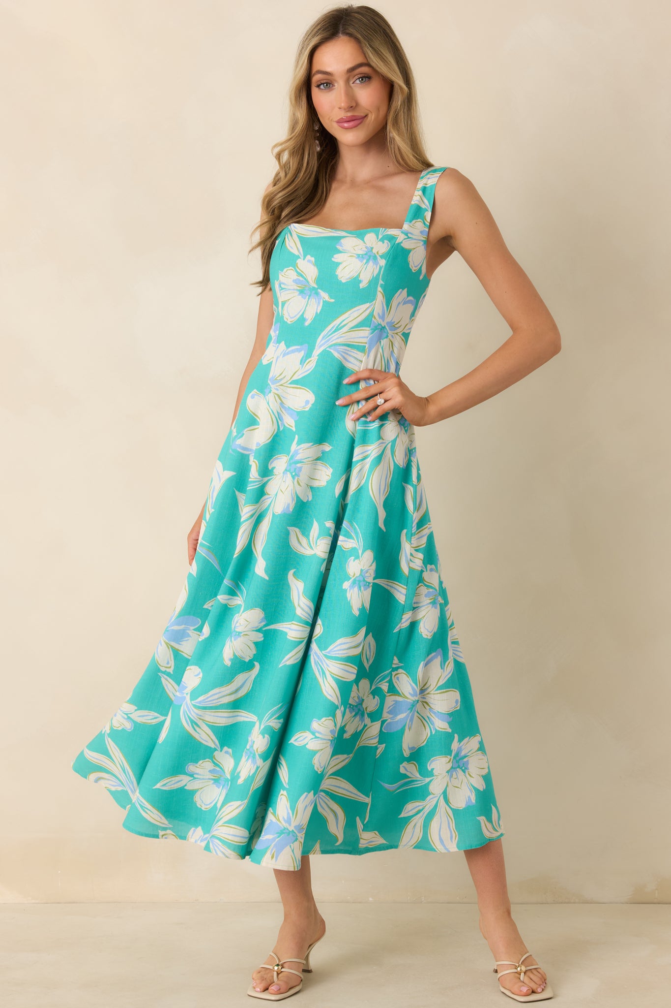 Turquoise sleeveless midi dress with square neckline, wide straps, tailored bodice, and softly flared A-line skirt.