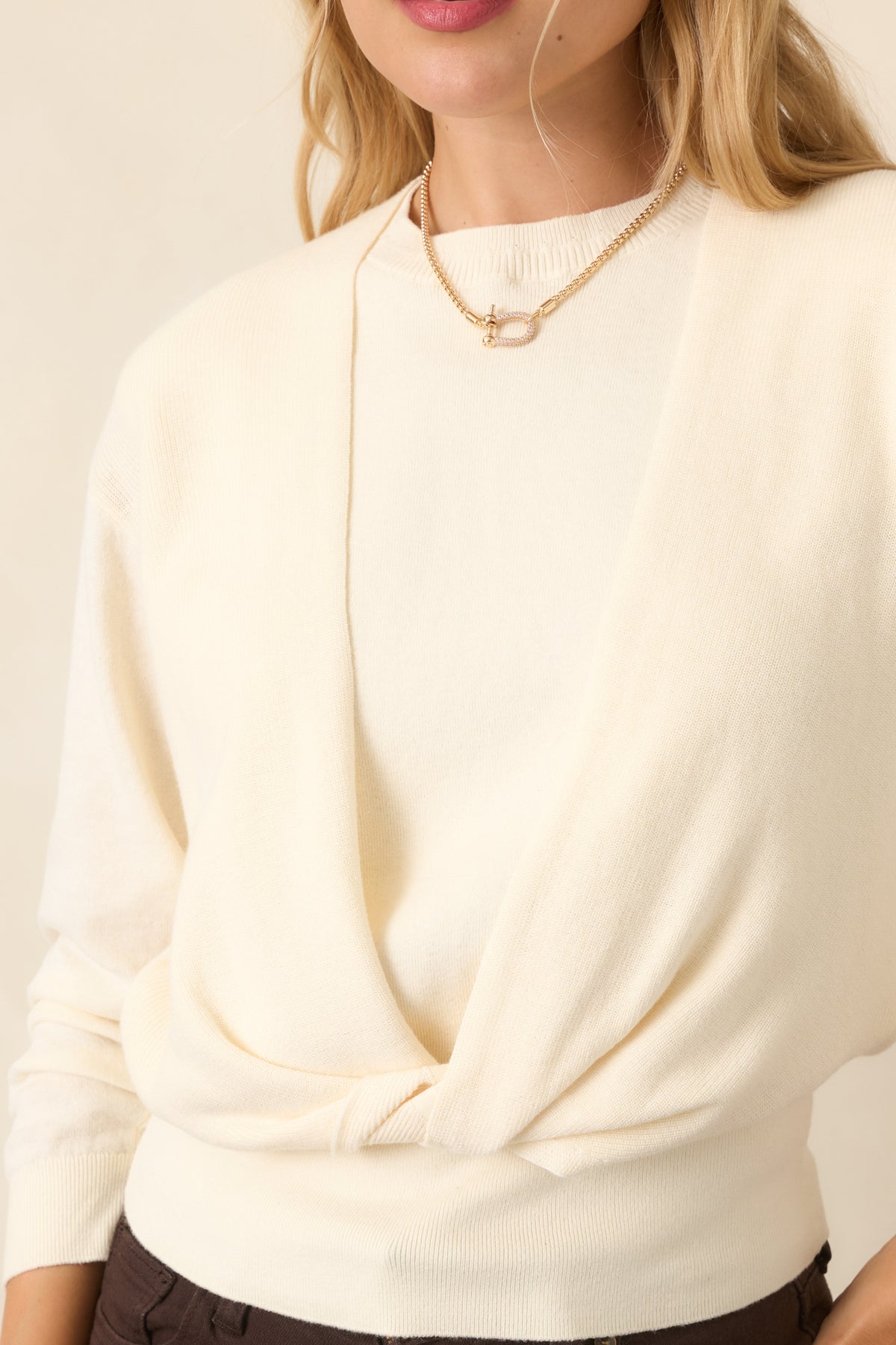 Close-up of the front twist construction showing the overlapping knit layers and wide ribbed hem.
