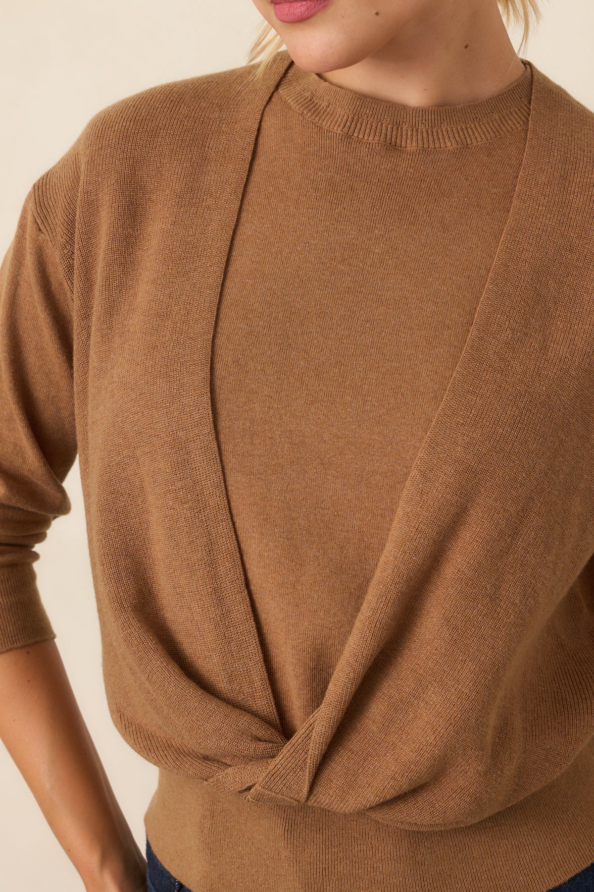 Close detail of the twisted front overlay and contrasting layered knit construction.
