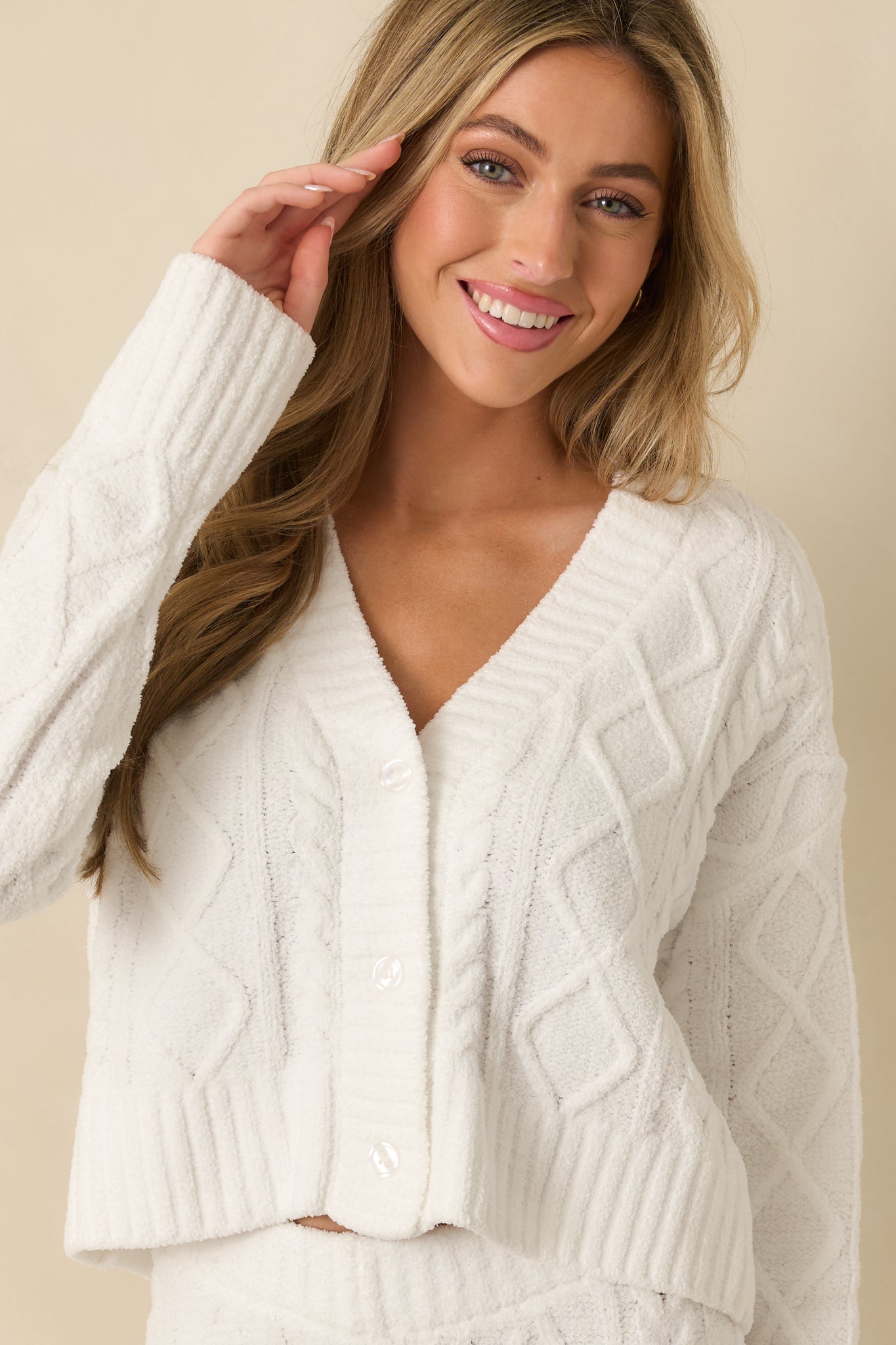 Upper torso crop highlighting the long sleeves and ribbed cuffs of the cardigan.