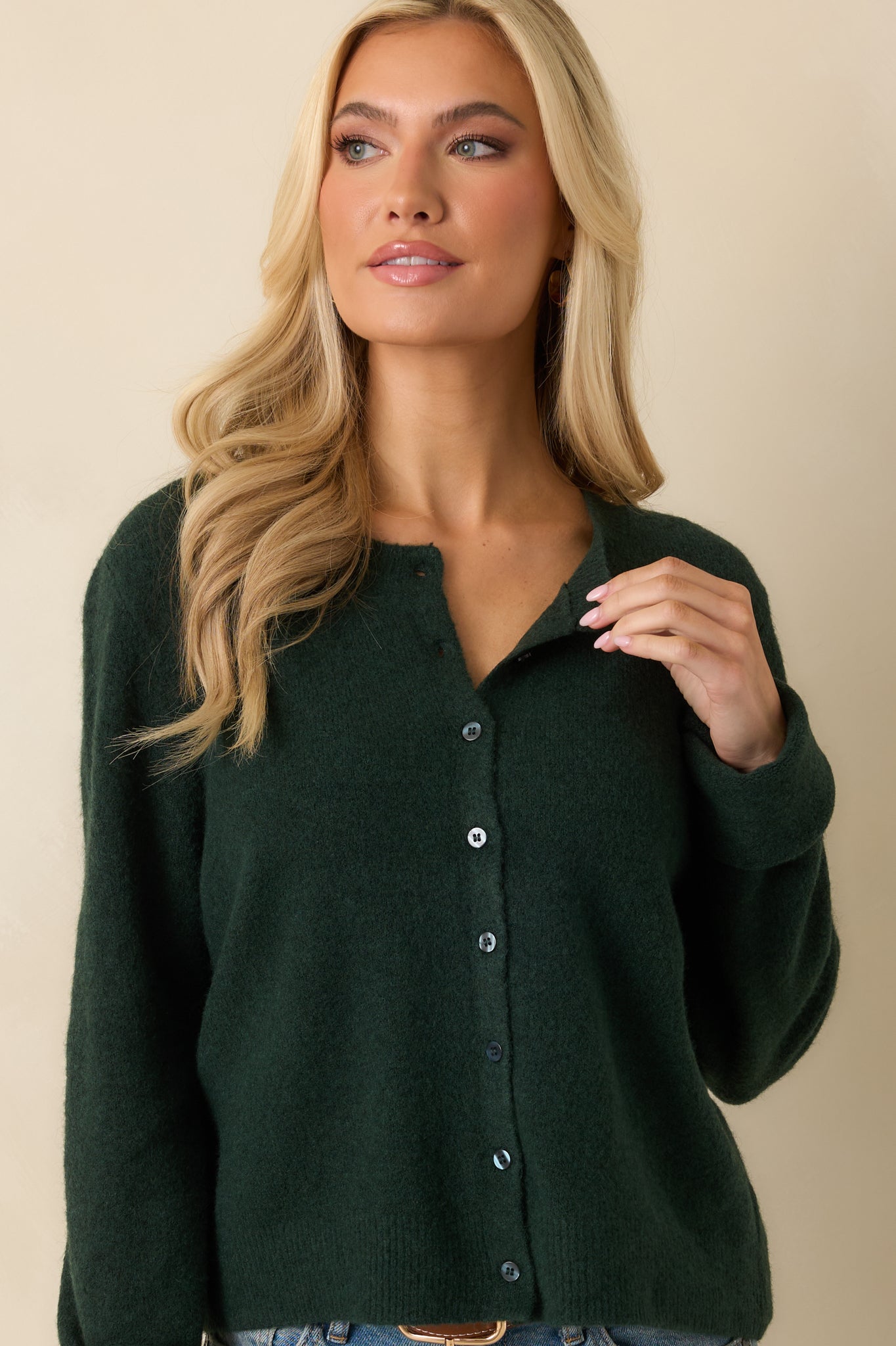 Upper torso crop focusing on ribbed crew neckline, button closure, and knit texture.