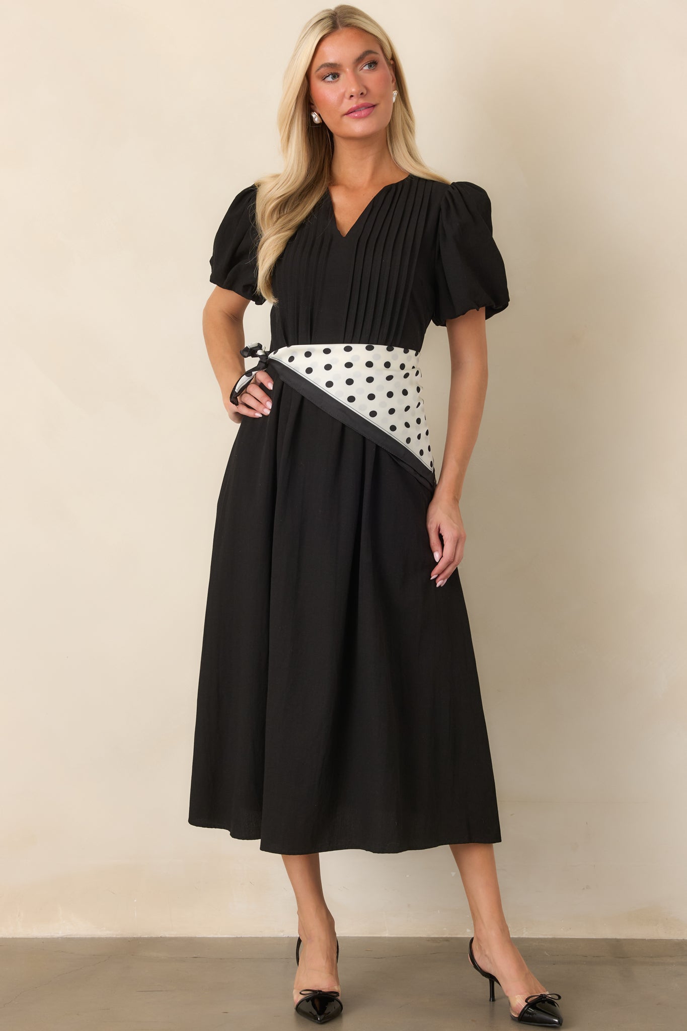 Flowing midi dress showcasing a clean V-neckline, gathered short sleeves, and structured pintuck accents through the bodice.