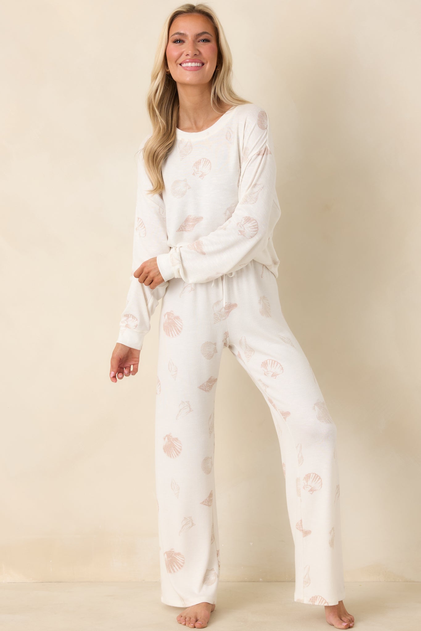 Vanilla-based long sleeve sweater featuring soft knit fabric, ribbed cuffs and hem, and subtle seashell pattern throughout.