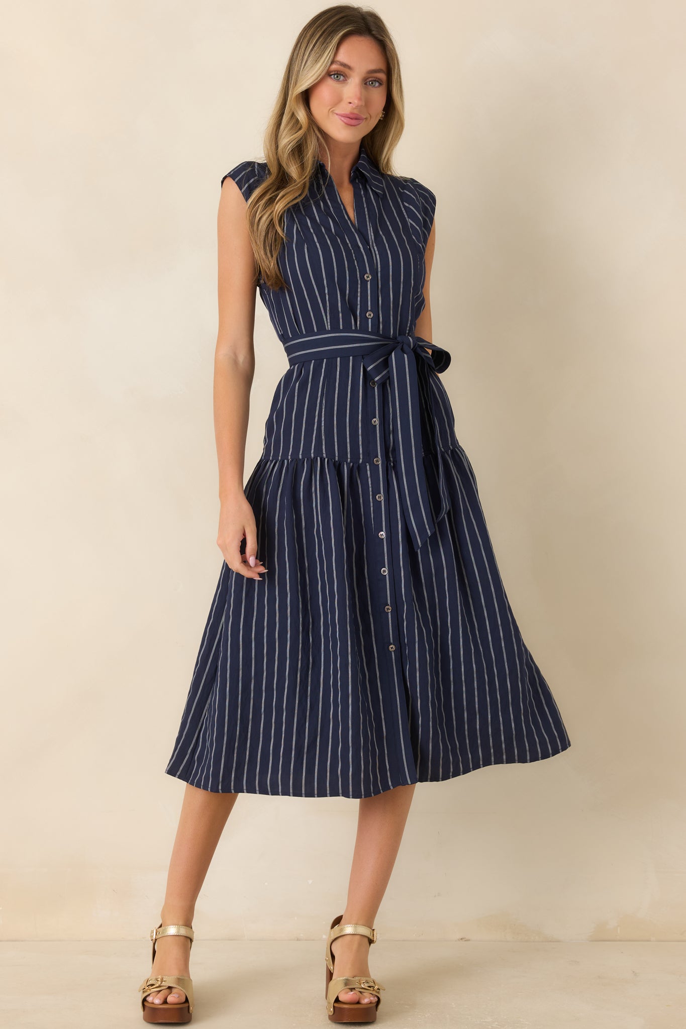 Lightweight sleeveless midi dress designed with vertical stripes, a defined waist tie, and relaxed skirt movement.